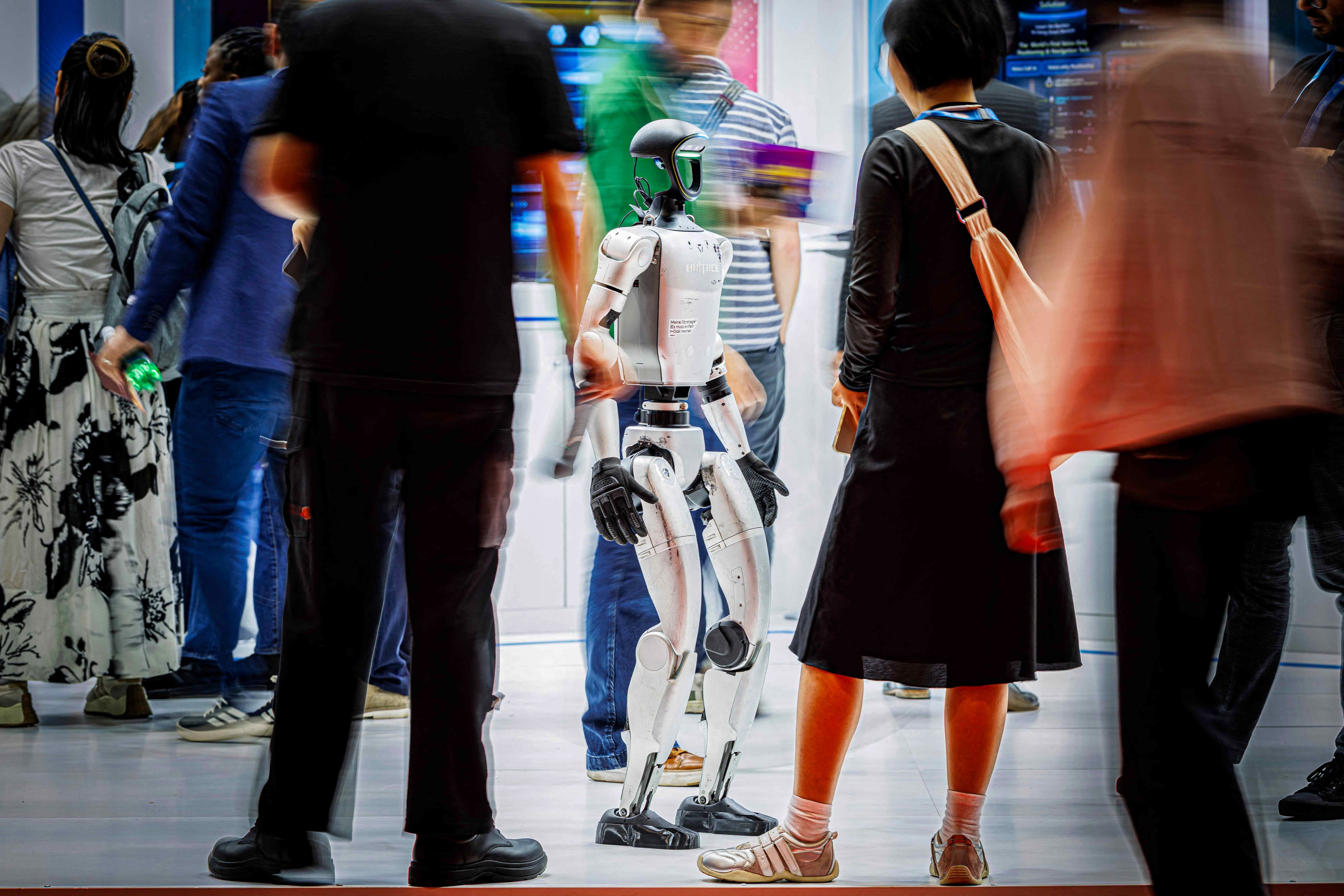 Visitors interact with an AI humanoid robot from Unitree at the International Telecommunication Union (ITU) AI for Good Global Summit in Geneva on July 8. Photo: AFP