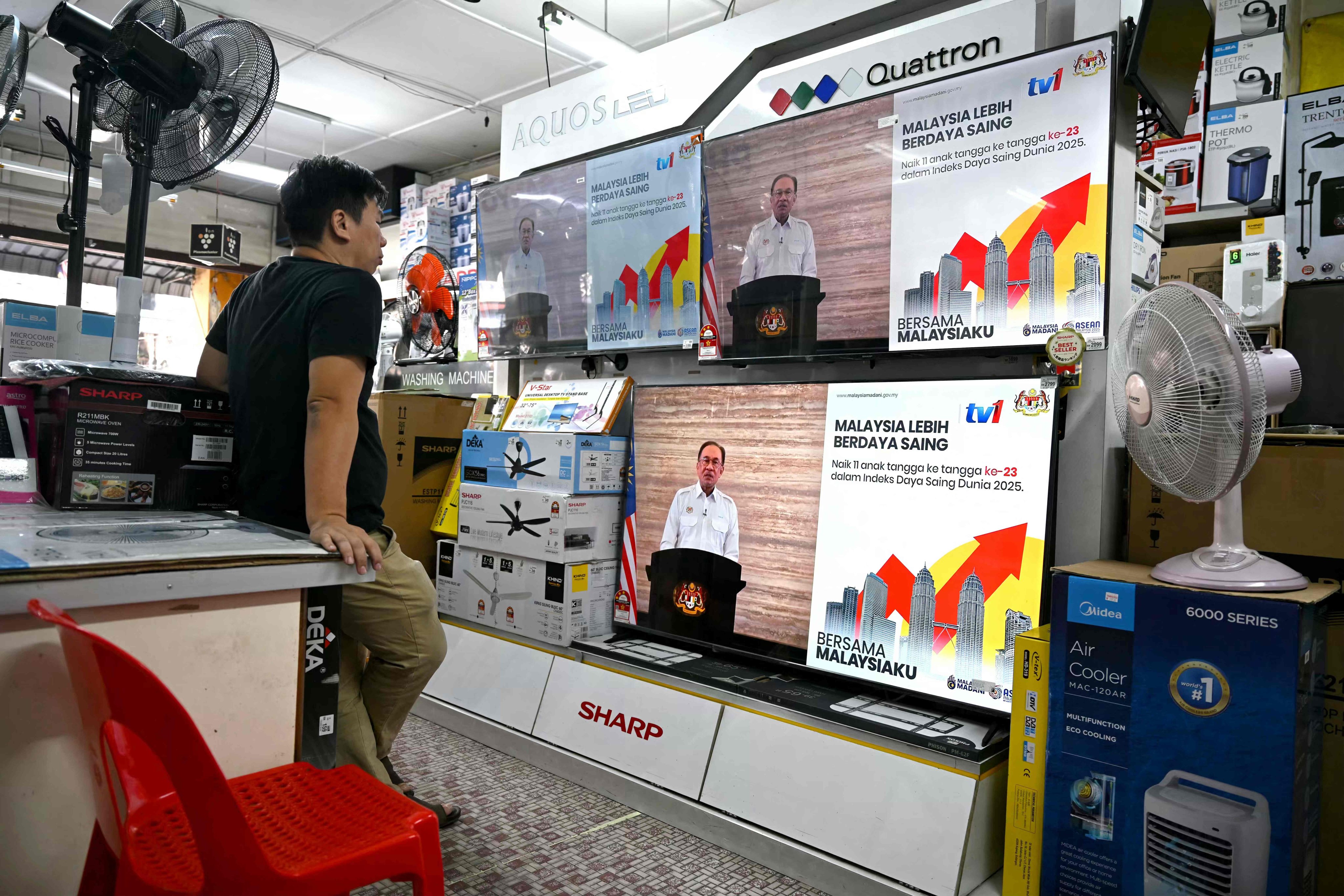 A man watches televisions on display at a shop as Malaysian Prime Minister Anwar Ibrahim addresses the nation during a live telecast on Wednesday. Photo: AFP