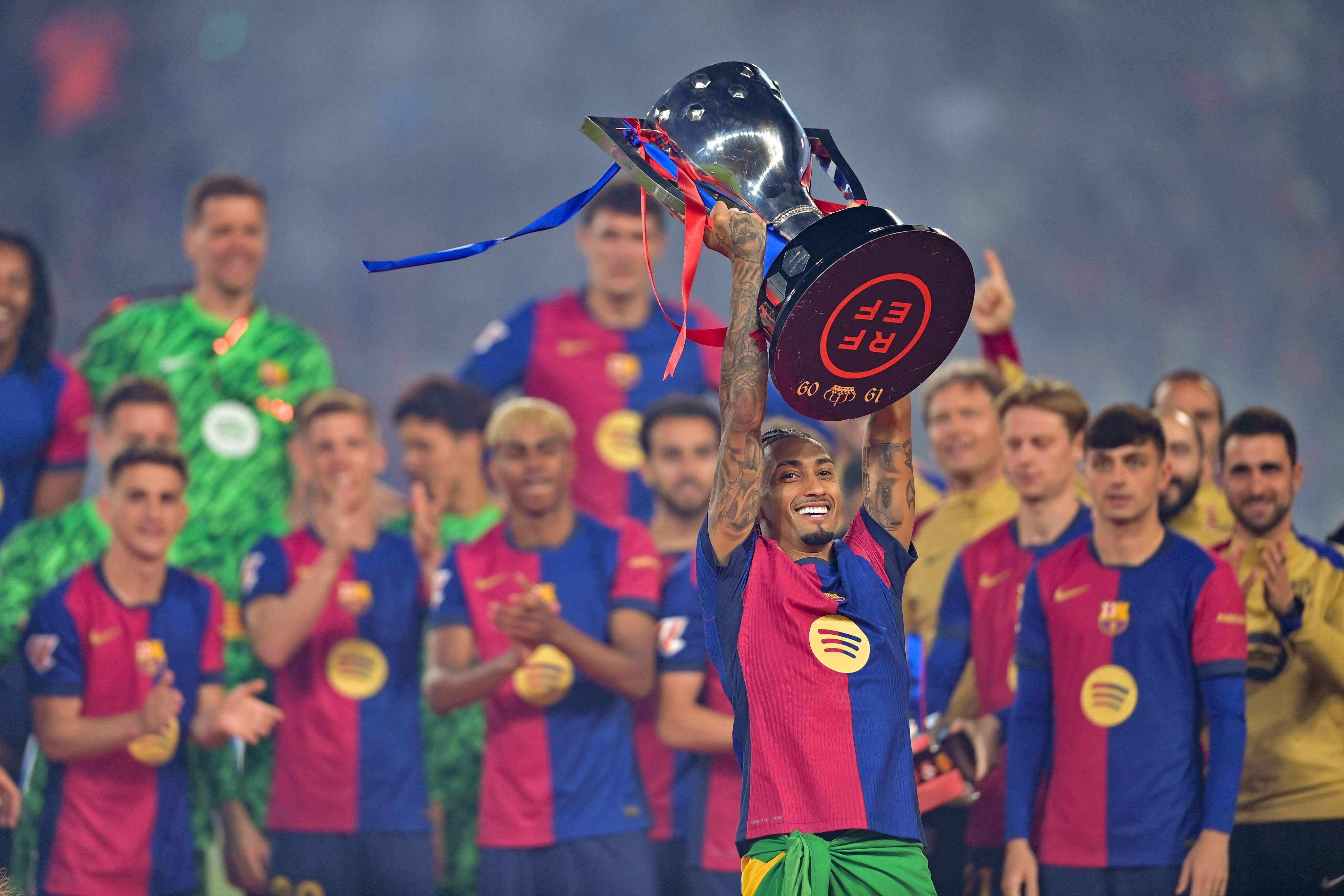 Barcelona’s Brazilian forward Raphinha raises the La Liga trophy as he celebrates with teammates after the match against Villarreal in May. Photo: AFP