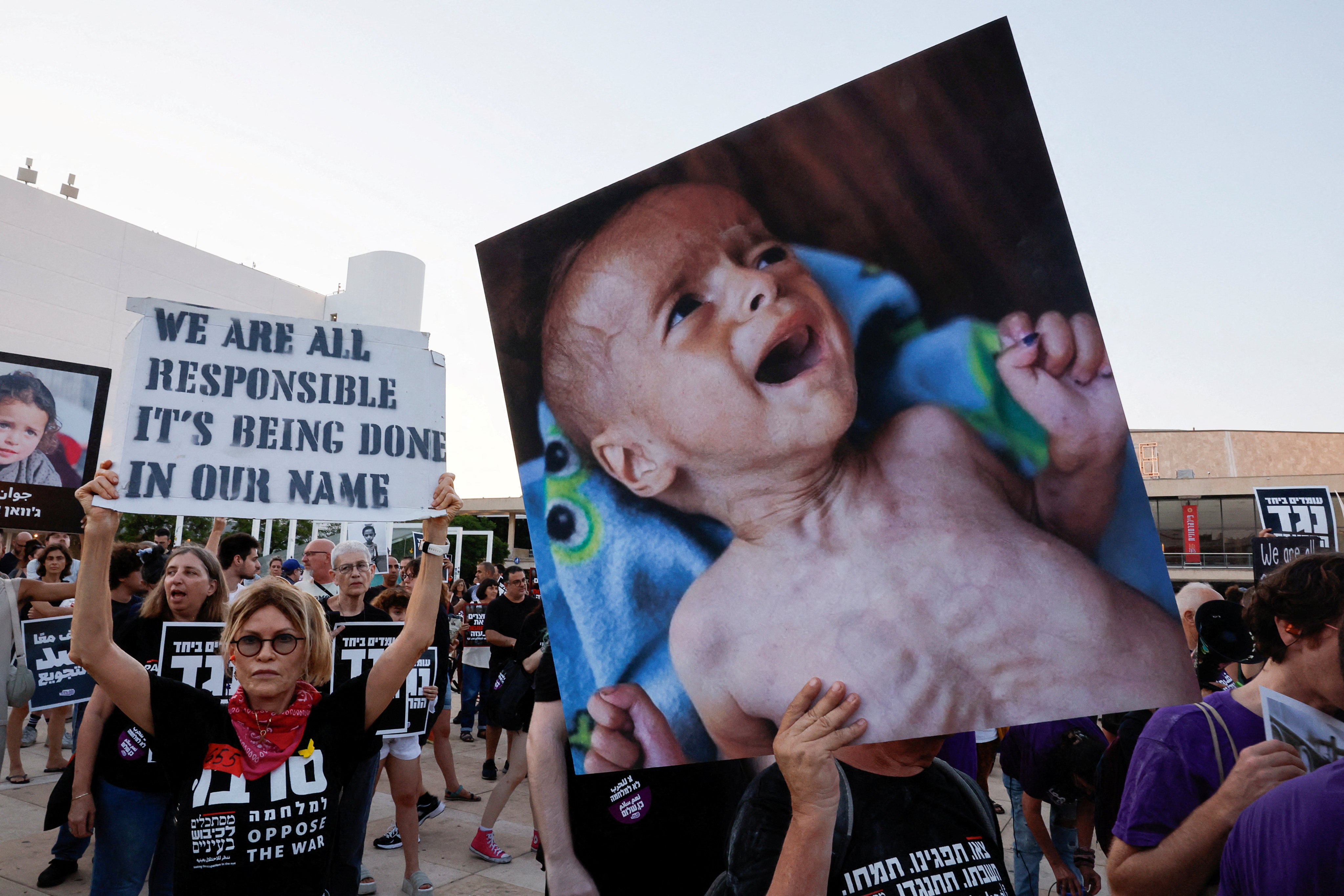 Demonstrators hold signs during a protest against the Gaza war in Tel Aviv, Israel on July 22. Photo: Reuters