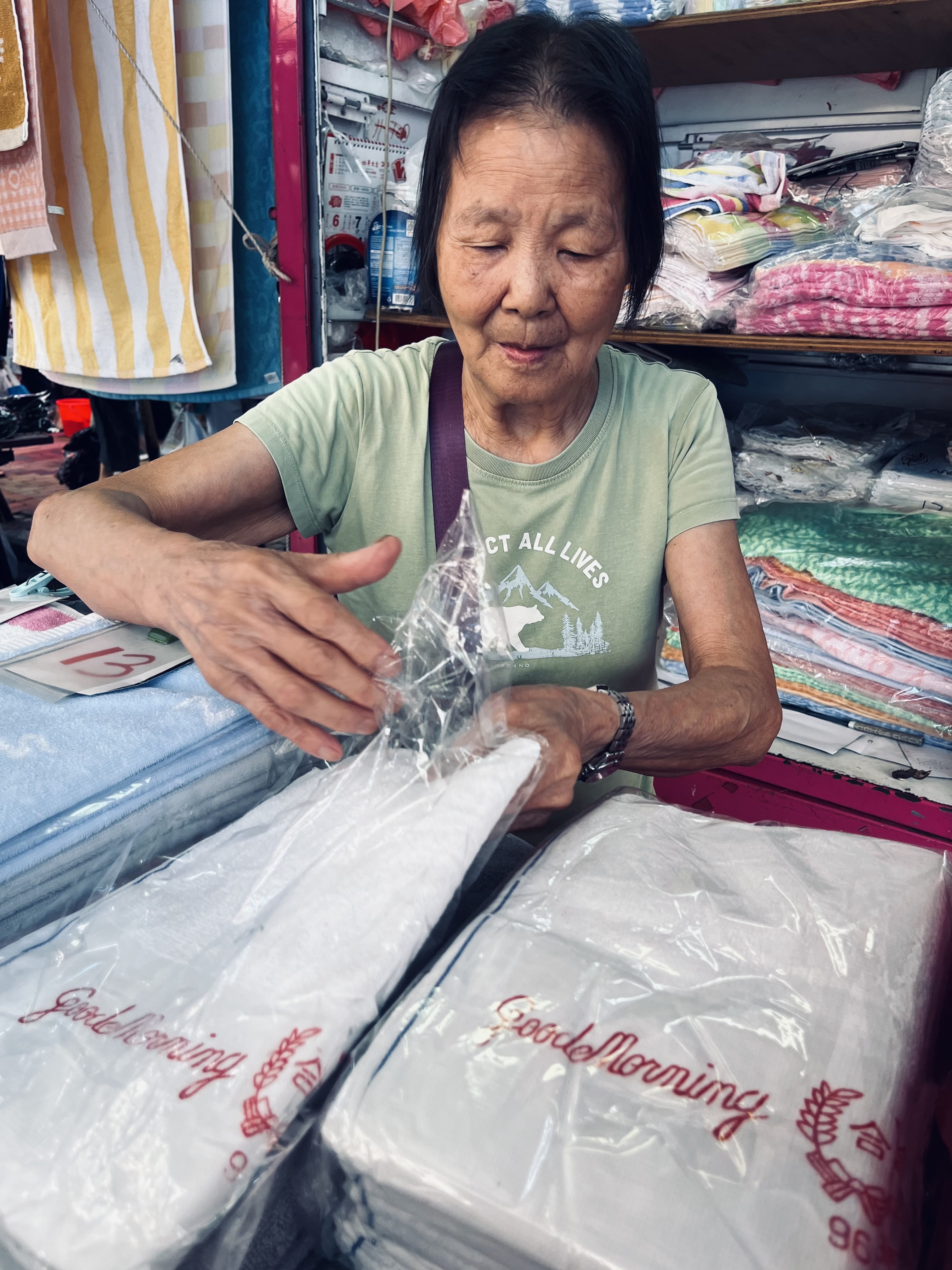A woman sells Good Morning towels at a stall in Hong Kong’s Sham Shui Po district on July 19, 2025. Photo: Kylie Knott