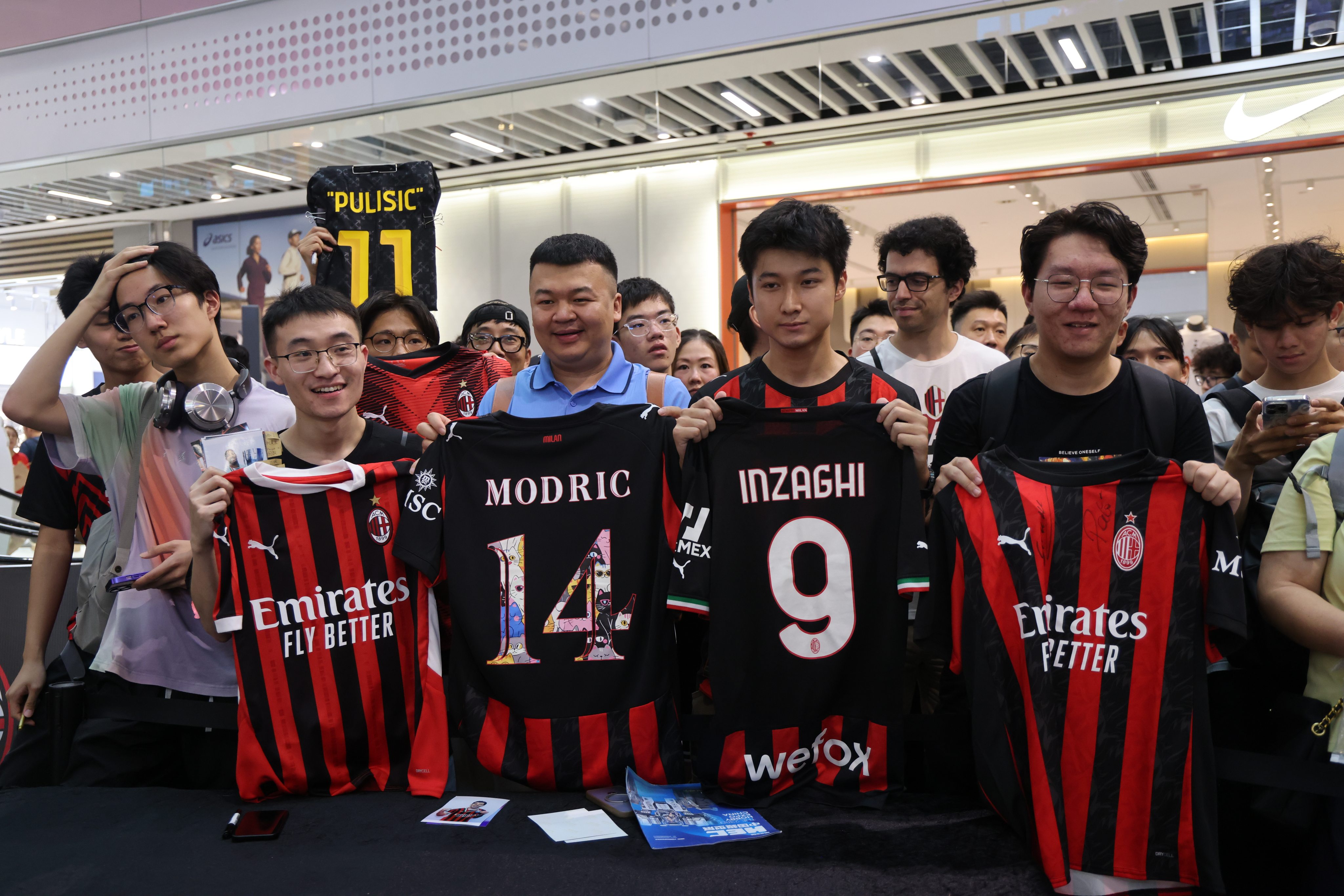 AC Milan fans holding player jerseys outside a Puma store at Kai Tak Mall 2 on Friday. Photo: Jelly Tse