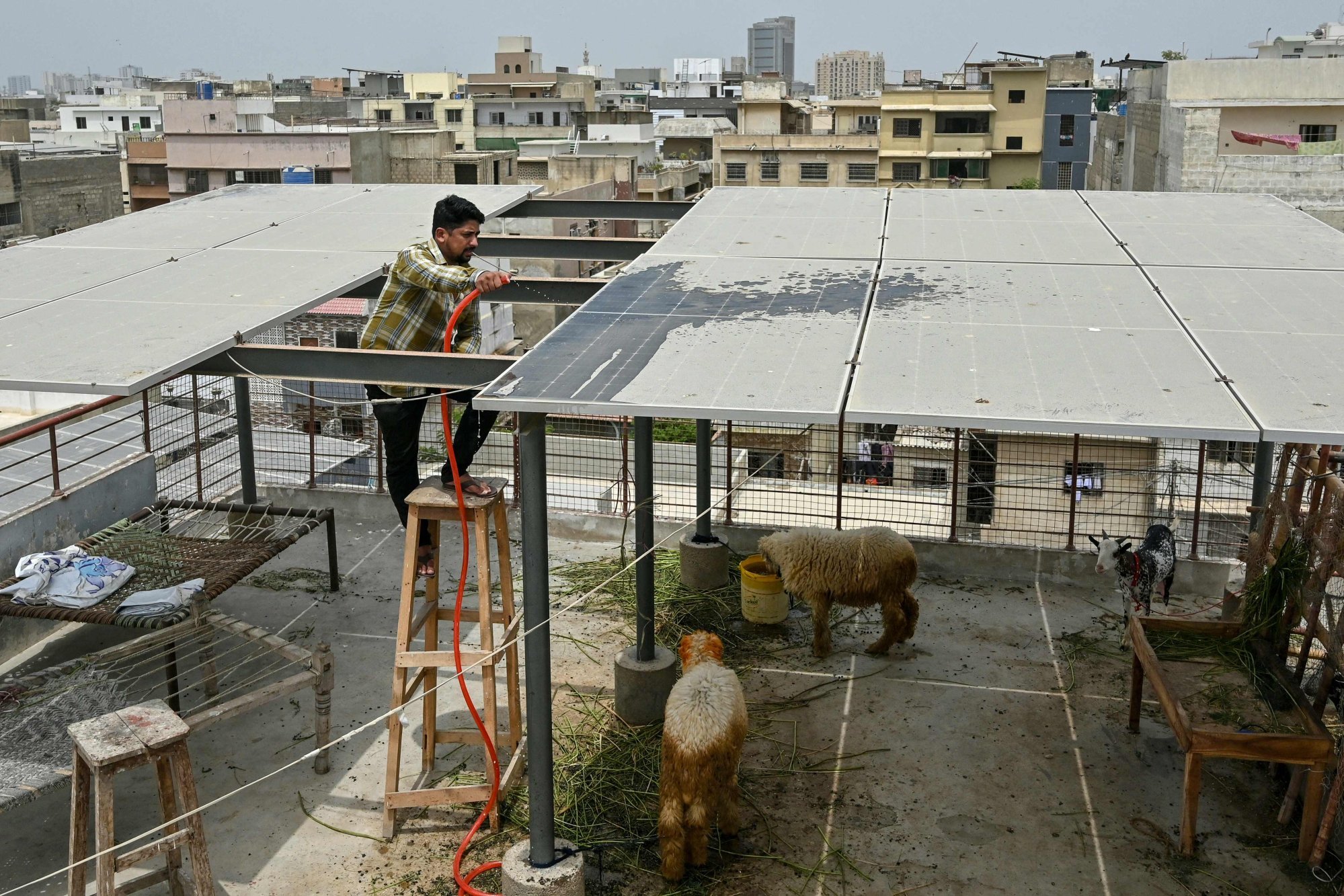 A Pakistani businessman cleans solar panels installed on the roof of his house in the port city of Karachi last month. Photo: AFP