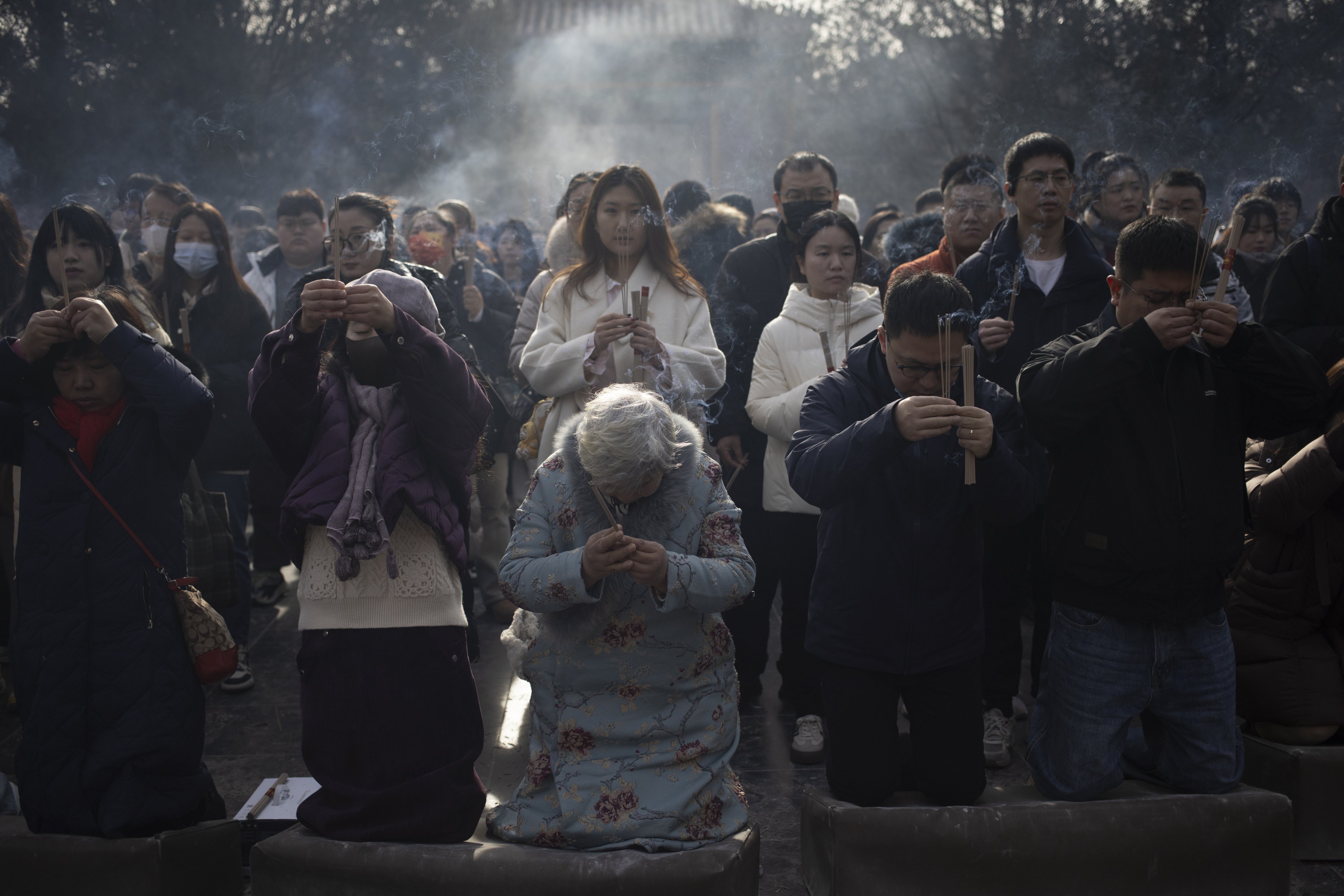 People young and old pray at Yonghe Temple in Beijing on January 1. After three decades of modernisation, many urban Chinese are spiritually adrift, restless and unsure of where to anchor their values in a fast-changing world. Photo: EPA-EFE