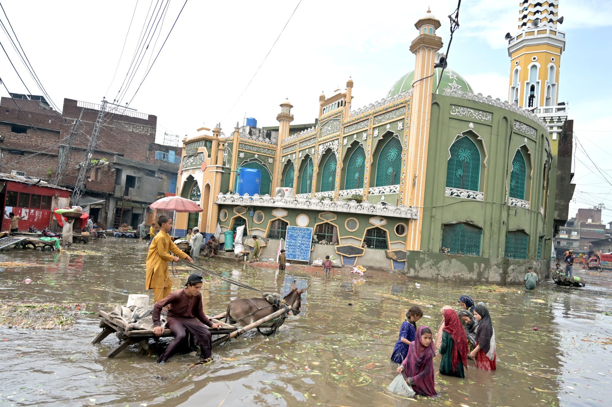People commute along a waterlogged road in Lahore, Pakistan, on Wednesday following torrential monsoon rains that killed hundreds. Photo: EPA