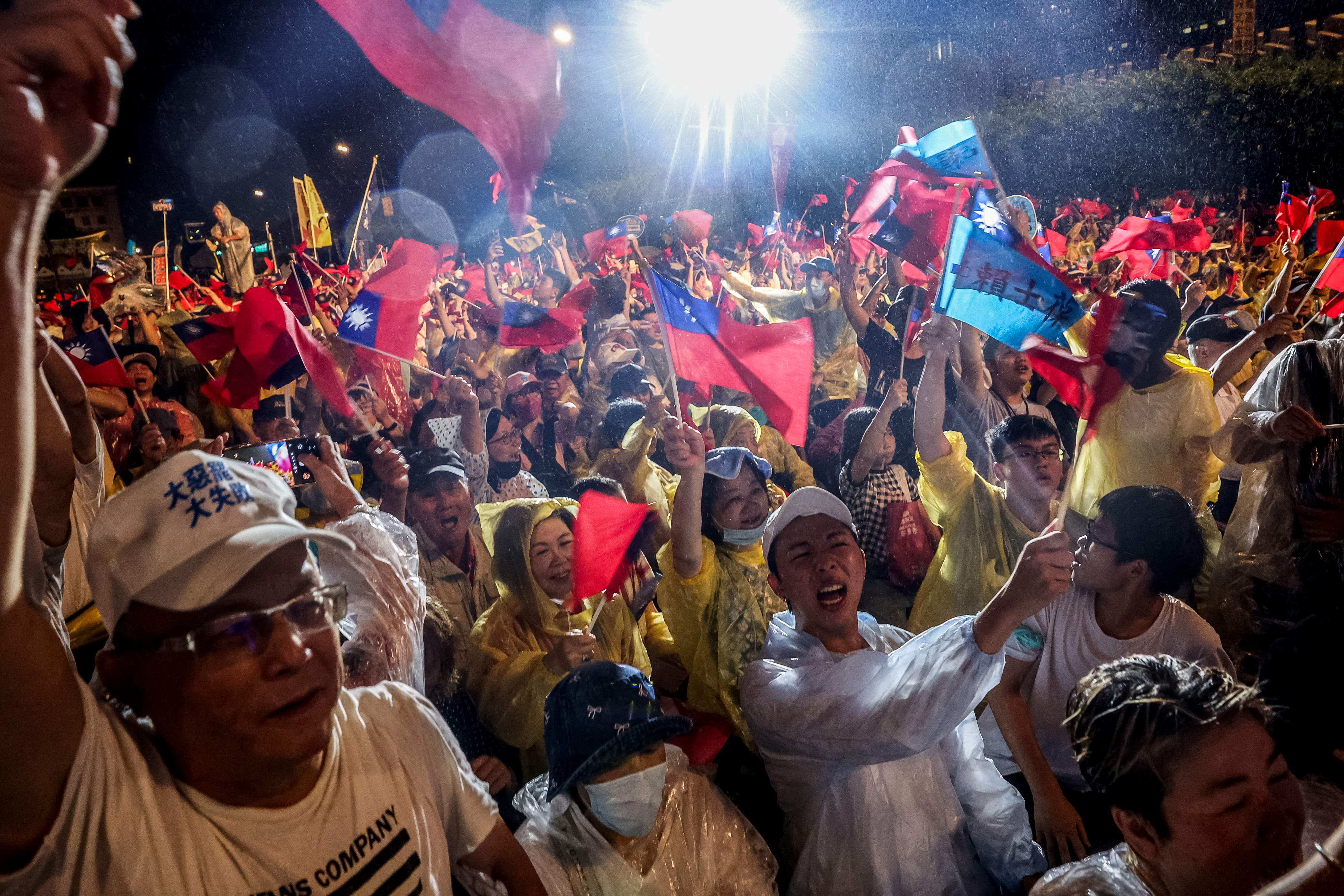 Supporters of Taiwan’s main opposition Kuomintang party defy the heavy rain to rally against the recall vote, in Taipei on Friday. Photo: AFP