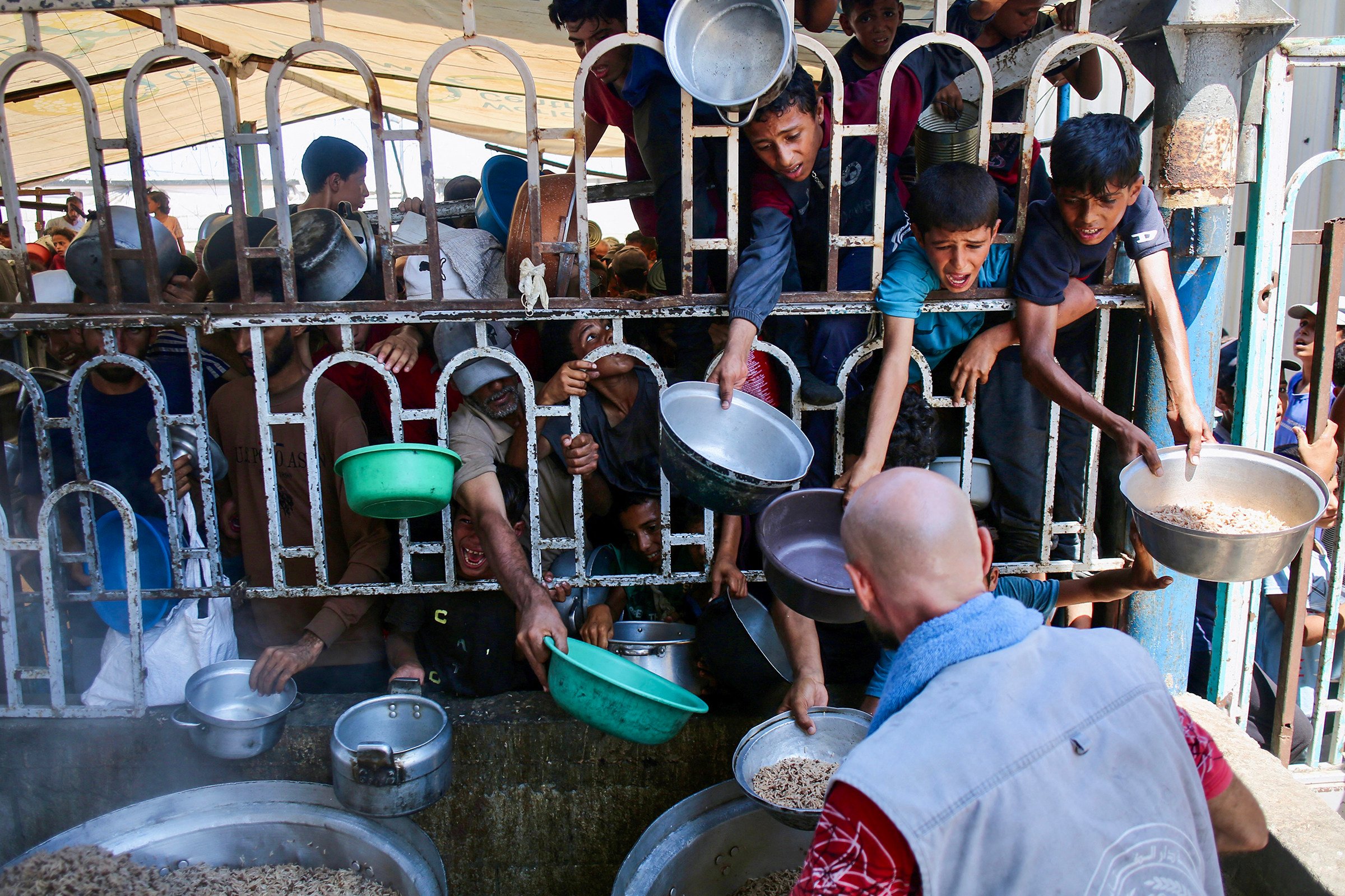 Palestinian children wait for a meal at a charity kitchen in Khan Younis in the southern Gaza Strip on Tuesday. Photo: TNS