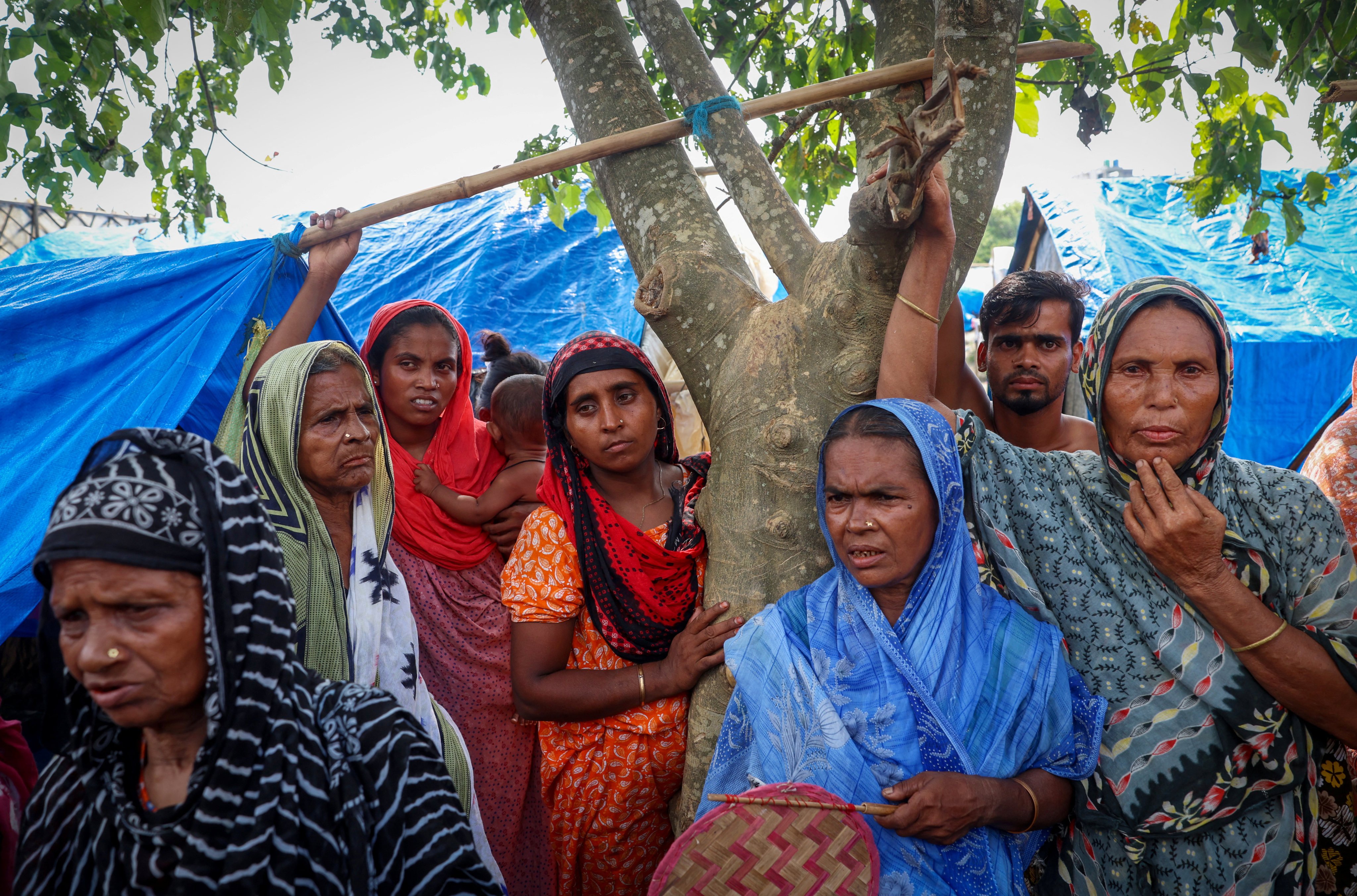 Women stand under a tree inside a makeshift shelter camp in Goalpara district in the northeastern state of Assam, India. Photo: Reuters