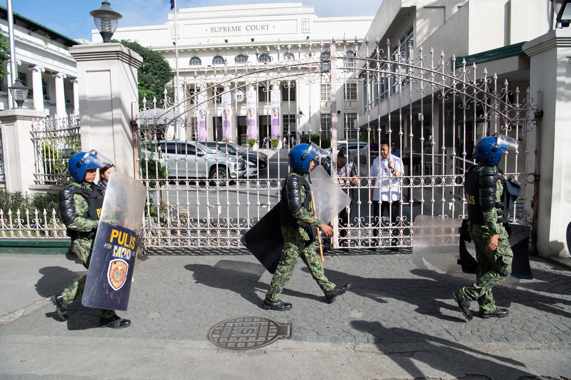 Policemen in anti-riot gear walk past the gates of the Philippine Supreme Court in March. Photo: AFP Policemen in anti-riot gear walk past the gates of the Philippine Supreme Court in March. Photo: AFP
