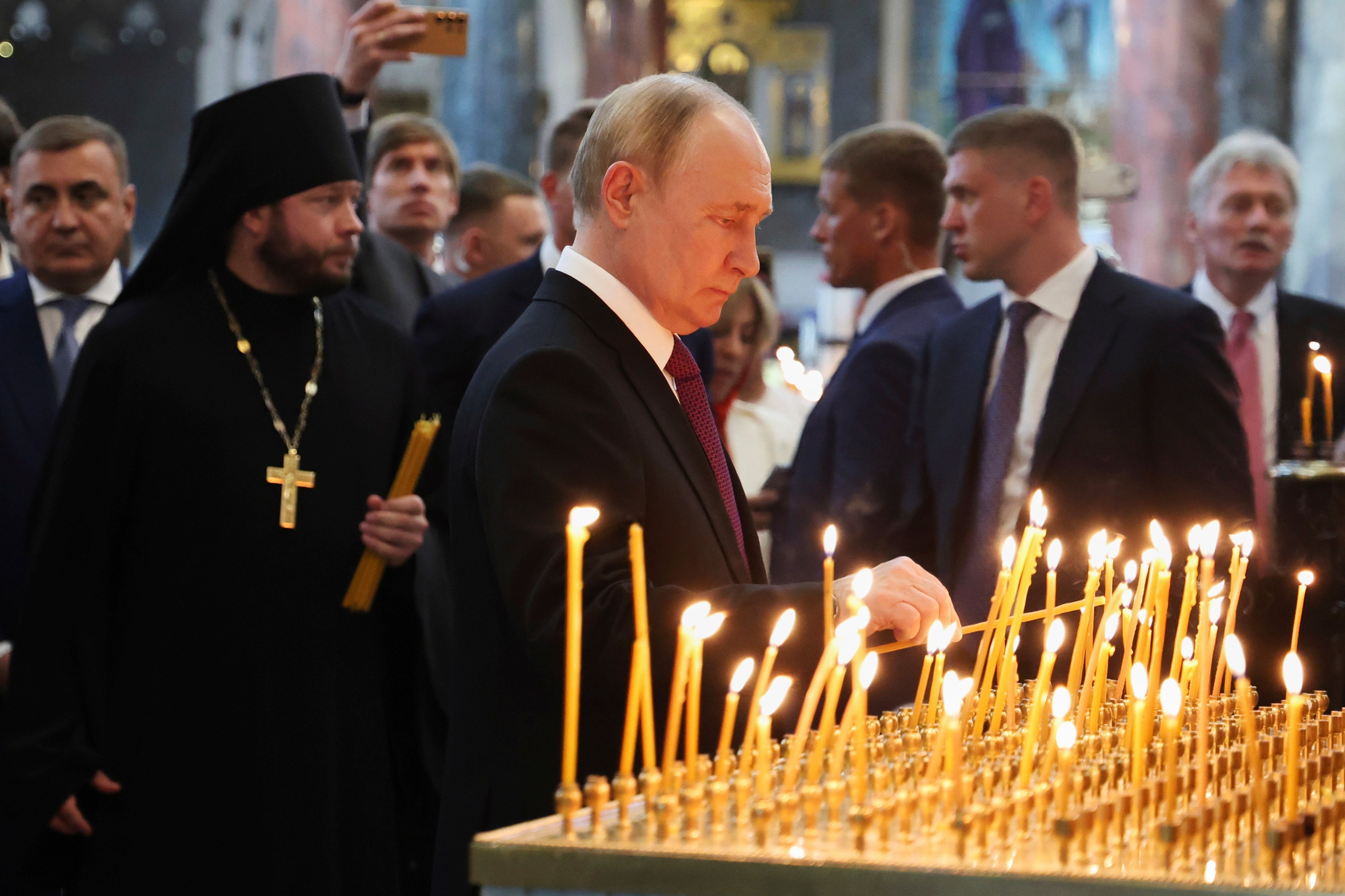 Russian President Vladimir Putin lights a candle as he visits the Naval Cathedral of Saint Nicholas in the city of Kronstadt, outside St. Petersburg during Navy Day celebration, Russia, on Sunday. Photo: AP