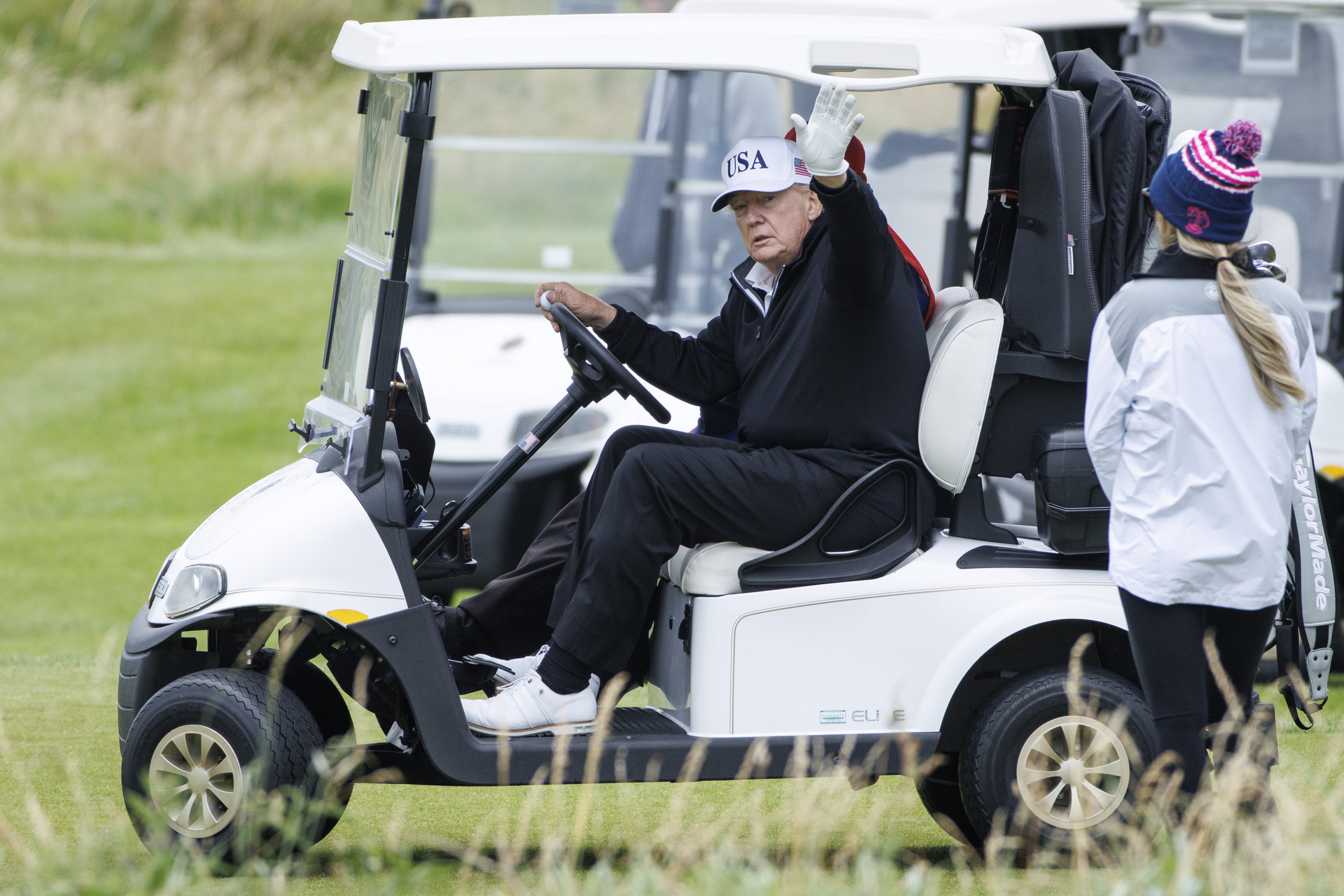 US President Donald Trump waves from his buggy at Trump Turnberry golf course during a private visit in Turnberry, Scotland, UK on Sunday. Photo: EPA