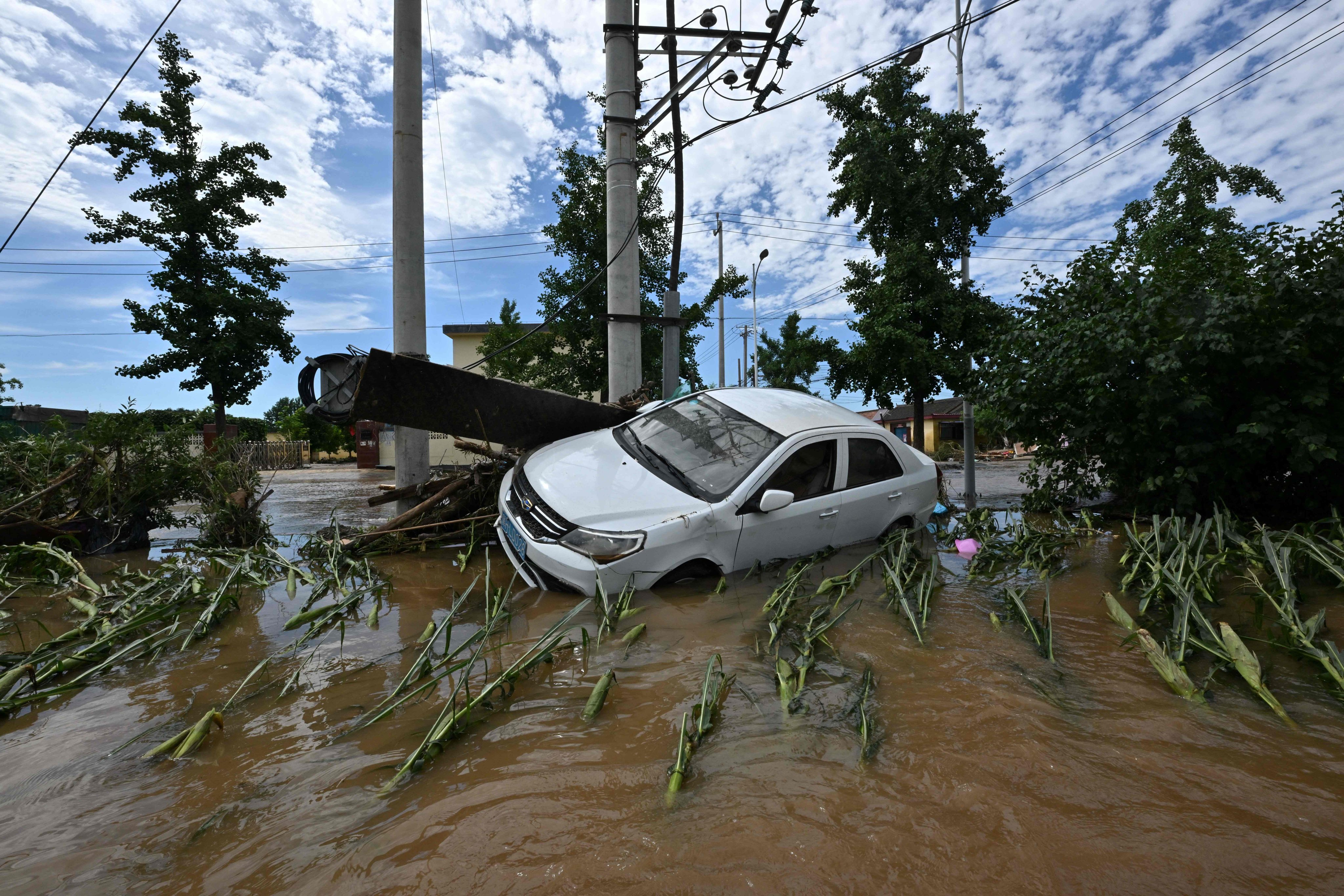 A damaged car is seen in a flooded neighbourhood in Miyun district, northern Beijing, on July 29. Photo: AFP