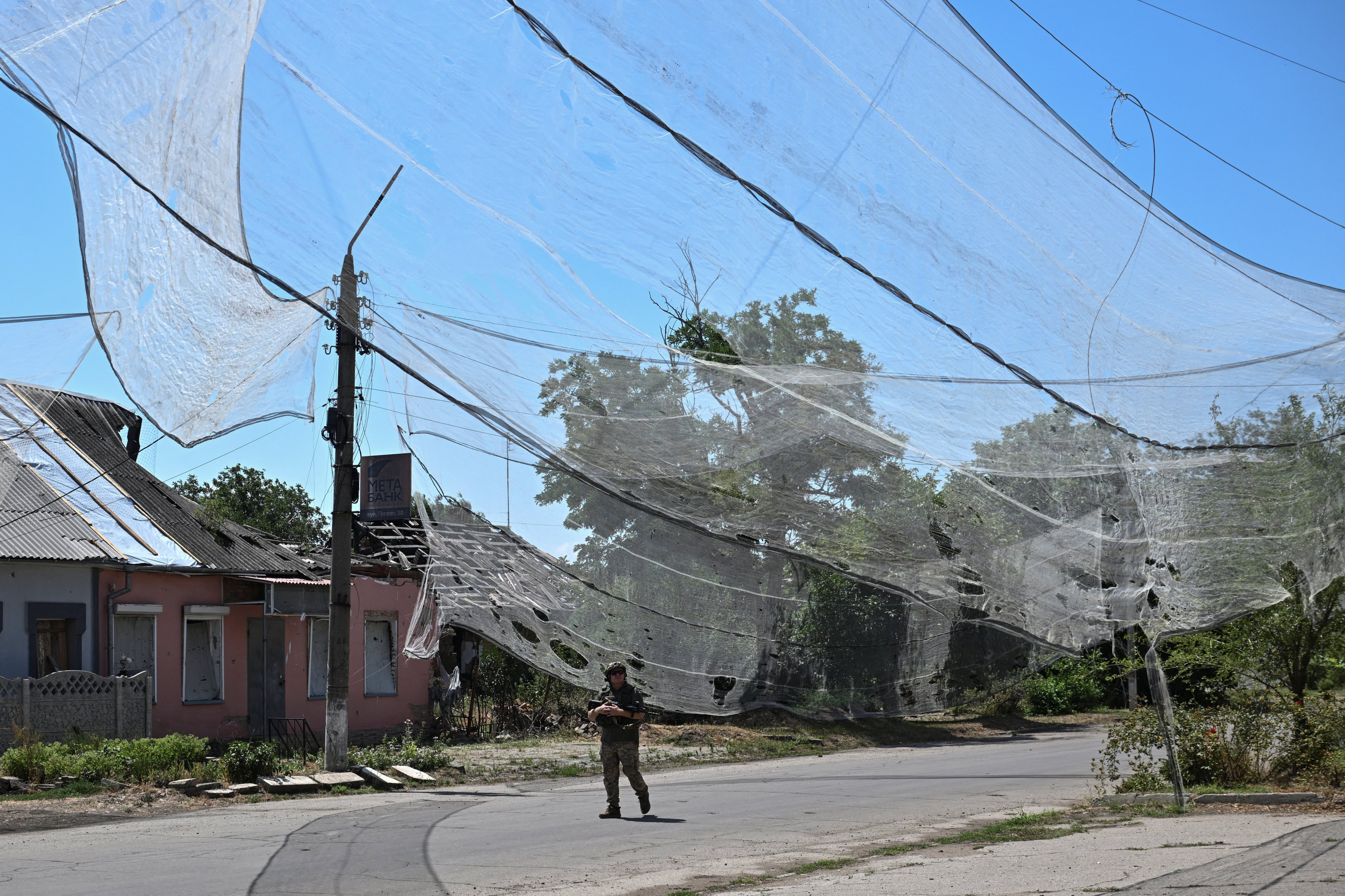 A Ukrainian soldier walks on a street protected with anti-drone nets in Ukraine’s frontline town of Orikhiv in Zaporizhzhia region on Wednesday. Photo: Reuters