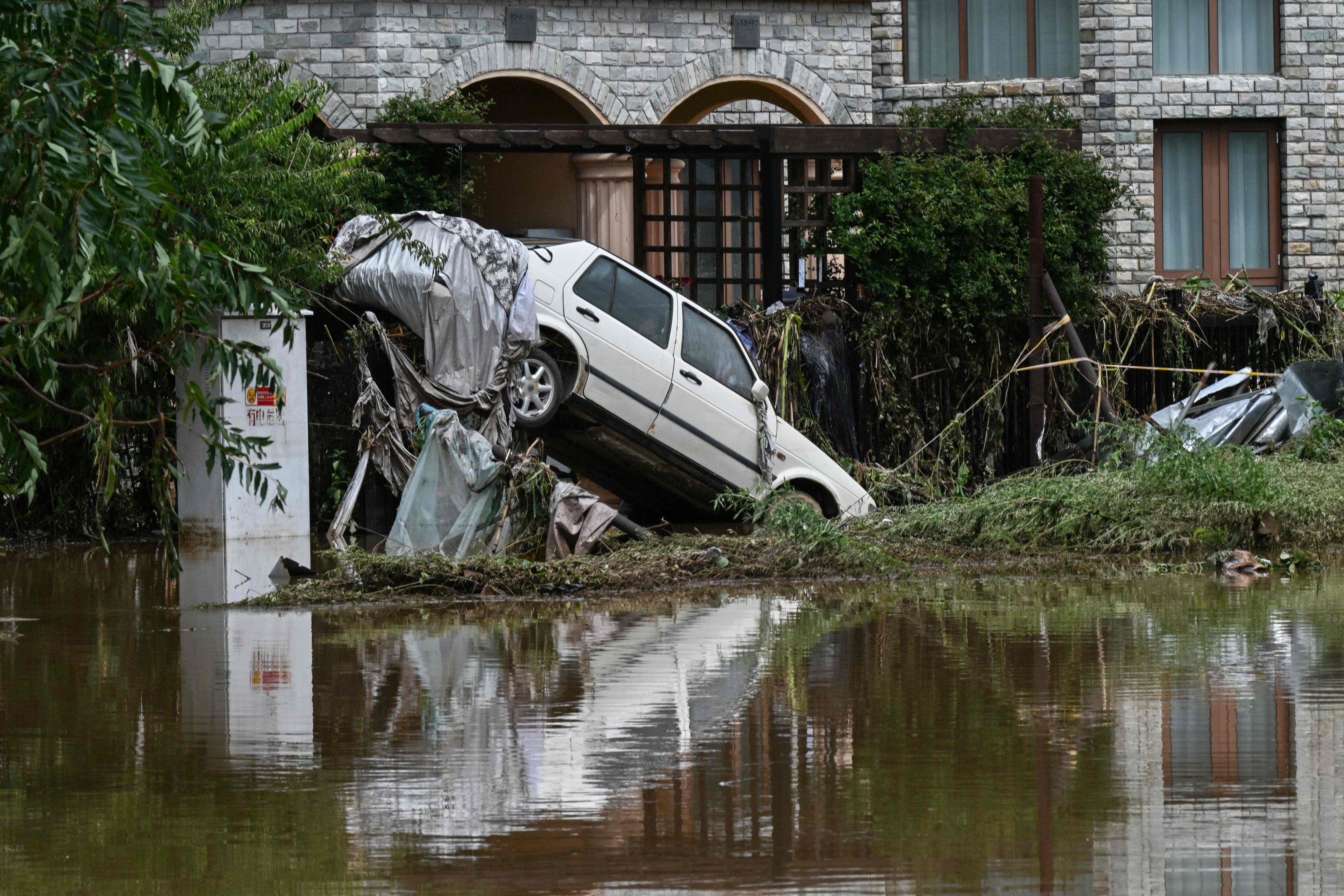 A damaged car is seen in a flooded neighbourhood in Miyun district, on the outskirts of Beijing on Tuesday. Photo: AFP