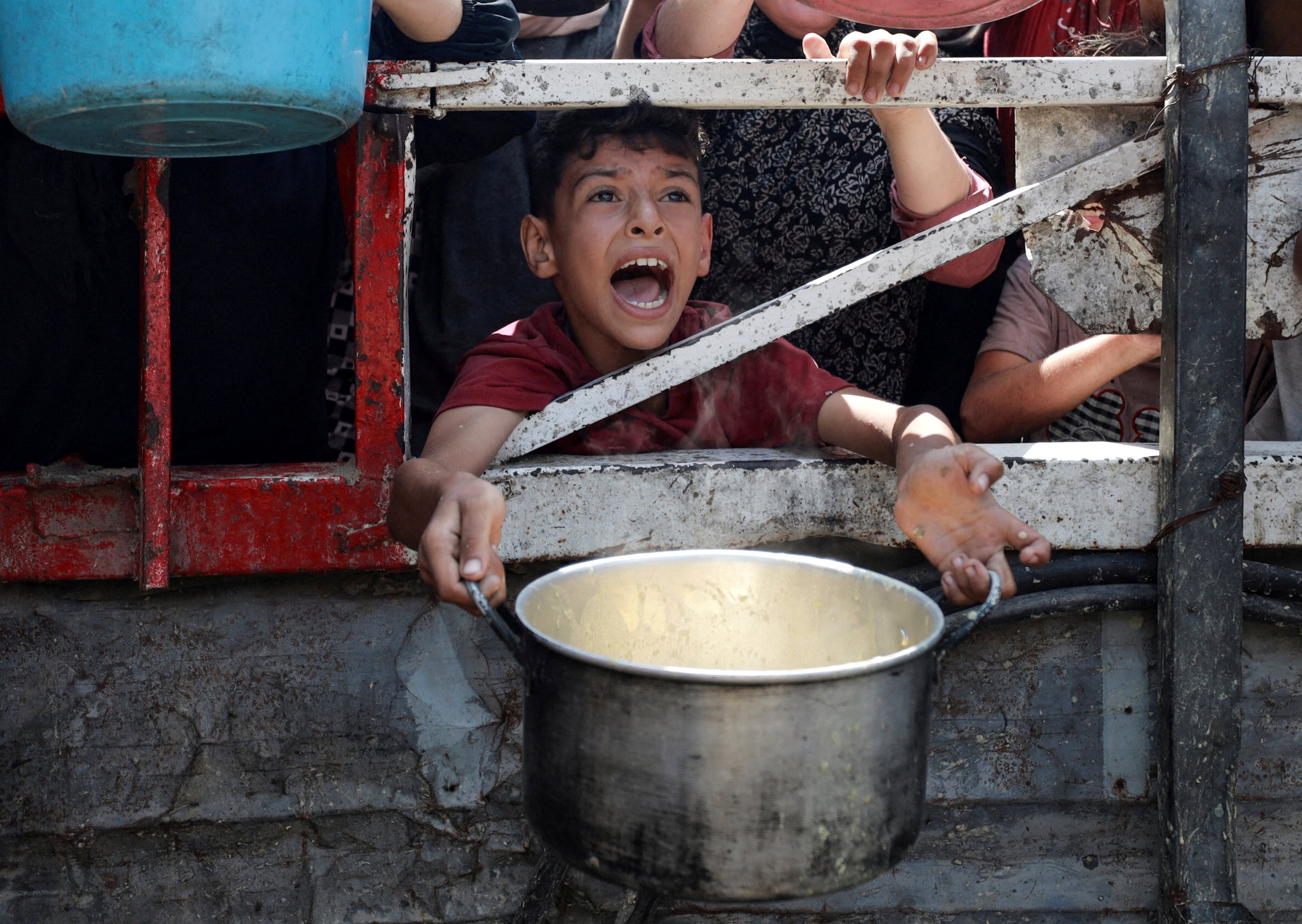 A Palestinian child reacts as he waits to receive food from a charity kitchen amid a hunger crisis in Gaza City on July 28. Photo: Reuters