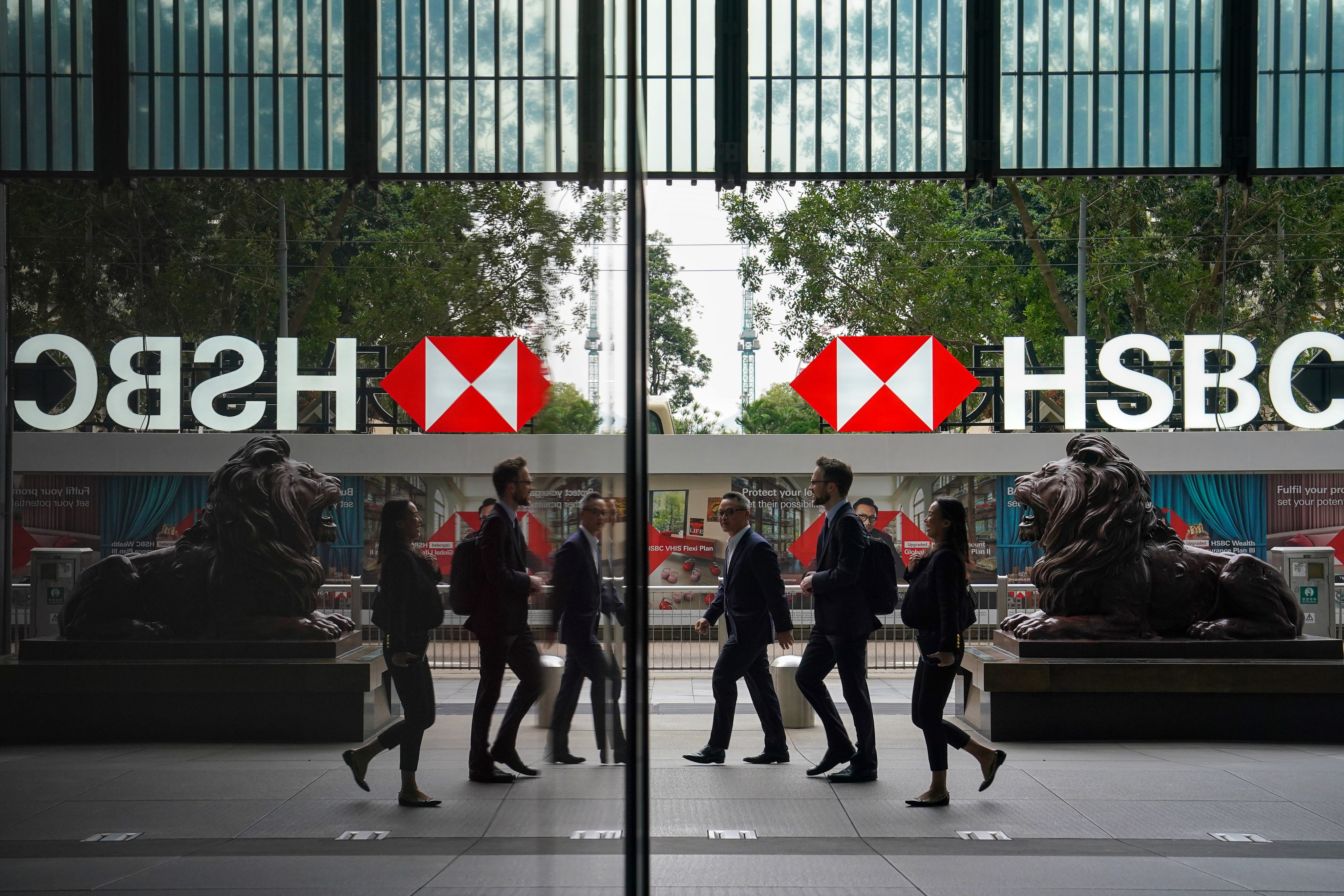 Office workers walk past lion statues outside HSBC’s main office building in Central. Photo: Elson Li