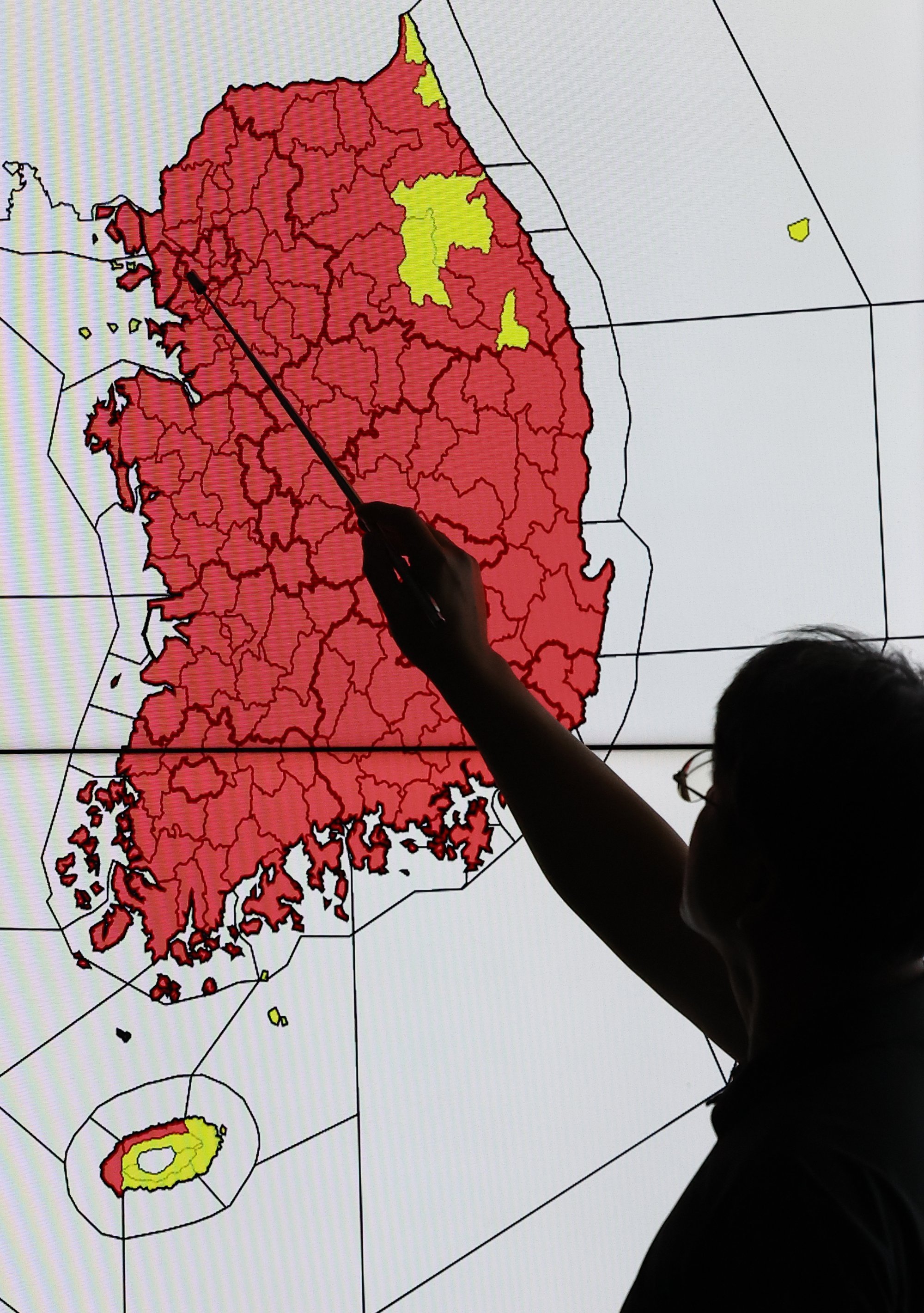 An official points to a map of South Korea indicating the areas for heat wave warnings in effect in red at the Korea Meteorological Administration in Seoul on Wednesday. Photo: EPA