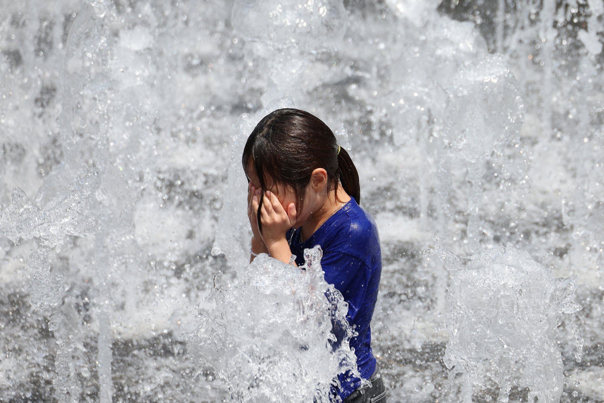 A girl plays in a fountain during a heatwave in central Seoul on Saturday. Photo: Reuters