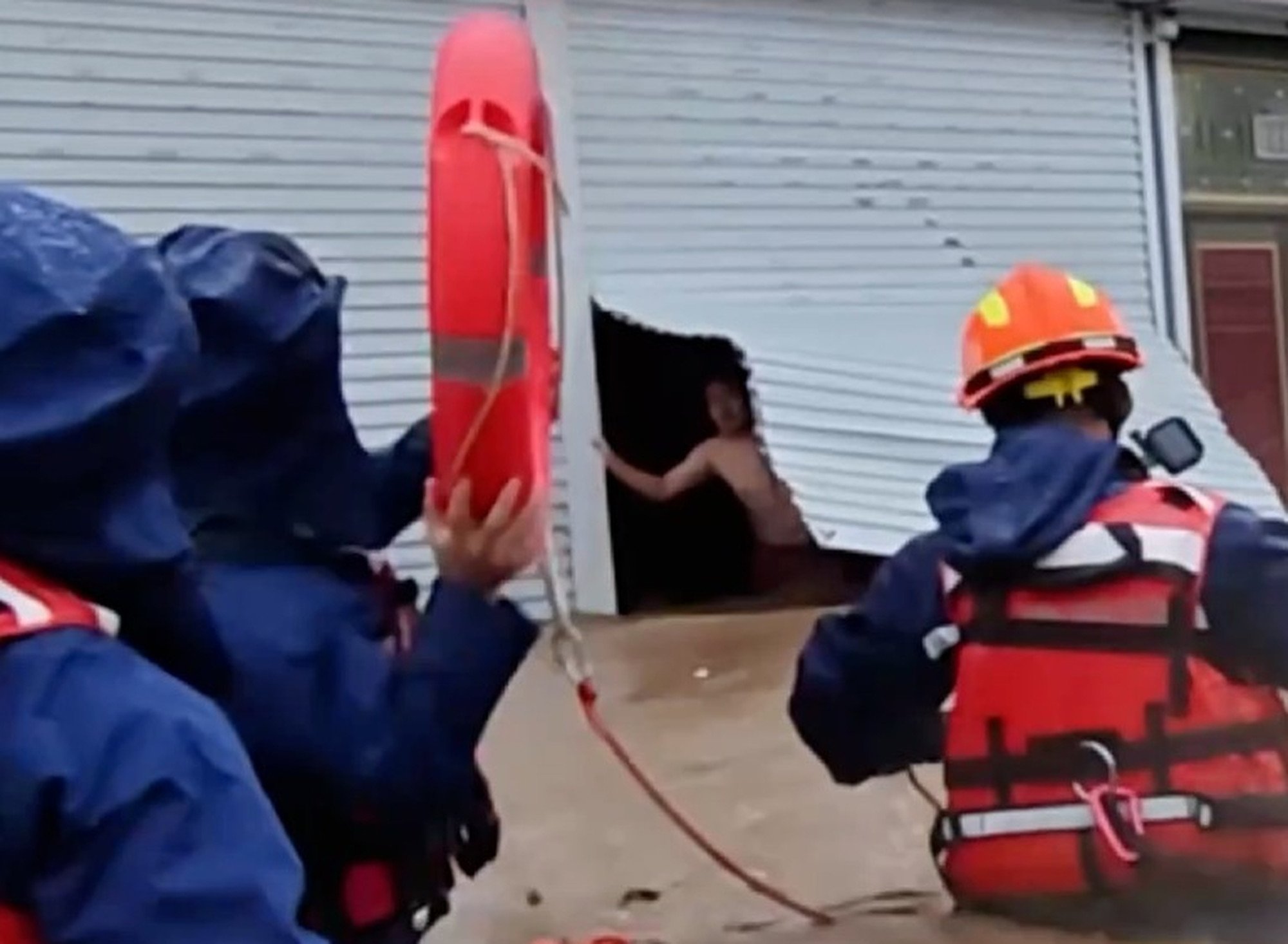 The husband can be seen looking out of his eatery as floodwaters rage around it and firefighters prepare to save him and his wife. Photo: Handout The husband can be seen looking out of his eatery as floodwaters rage around it and firefighters prepare to save him and his wife. Photo: Handout