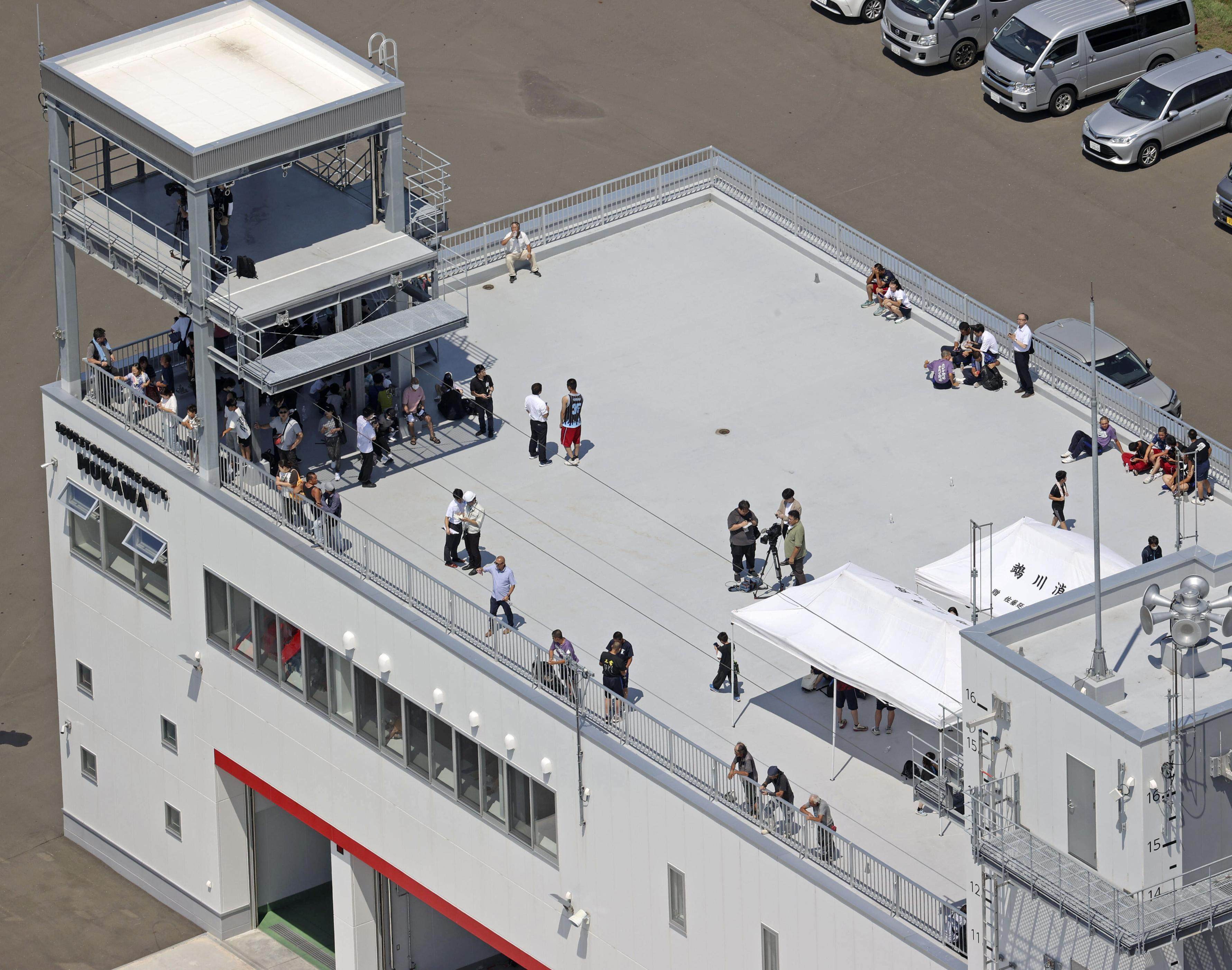 People evacuated to the rooftop of a fire department building in Hokkaido, northern Japan. A tsunami warning for the country’s Pacific coast was issued following a powerful earthquake off Russia’s Kamchatka Peninsula. 
Photo: Kyodo