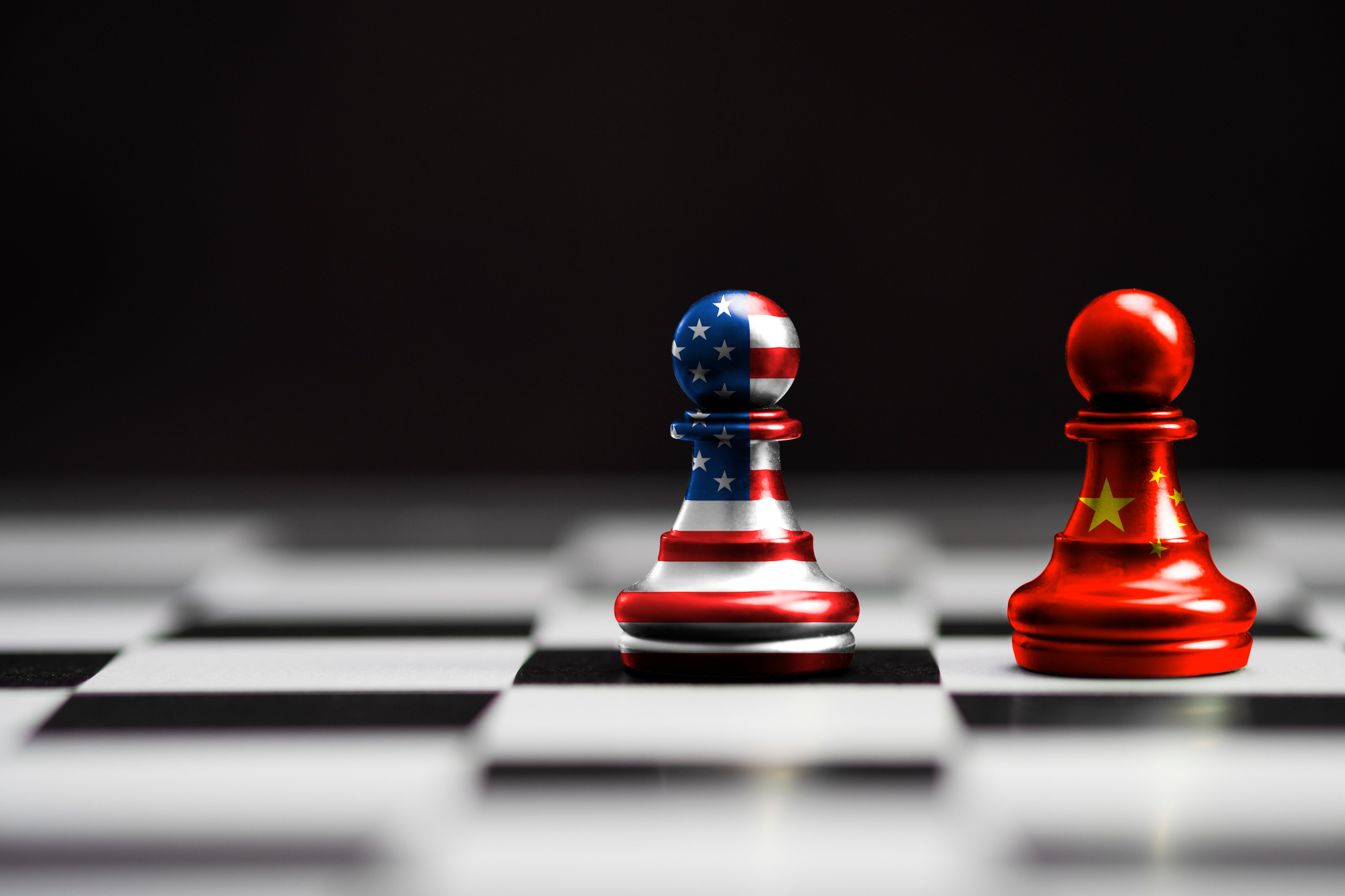 US and China flags printed on pawns on a chessboard. Photo: Shutterstock