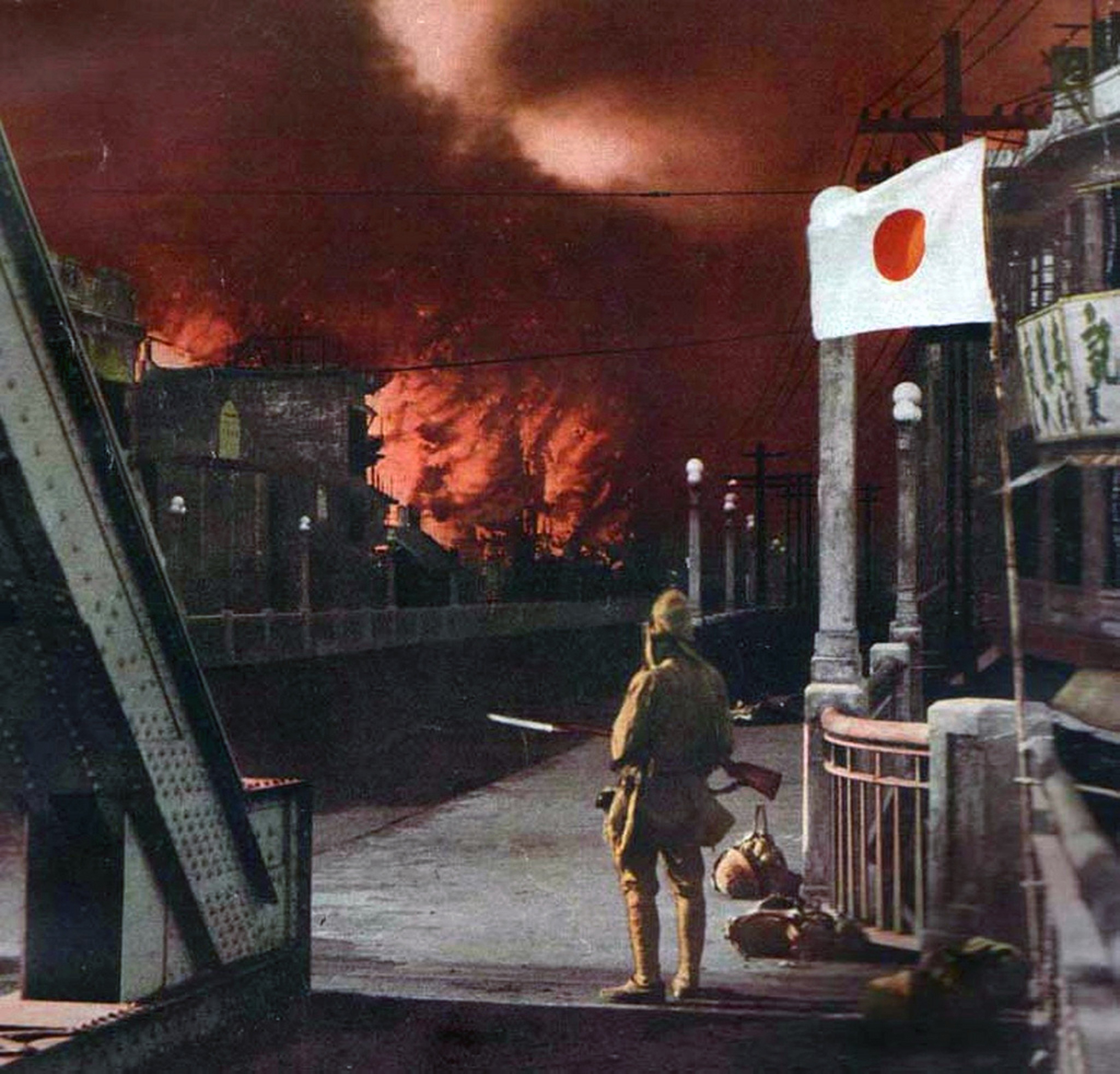 A Japanese soldiers watches a burning building in this colourised image dated 1945. Photo: Getty Images