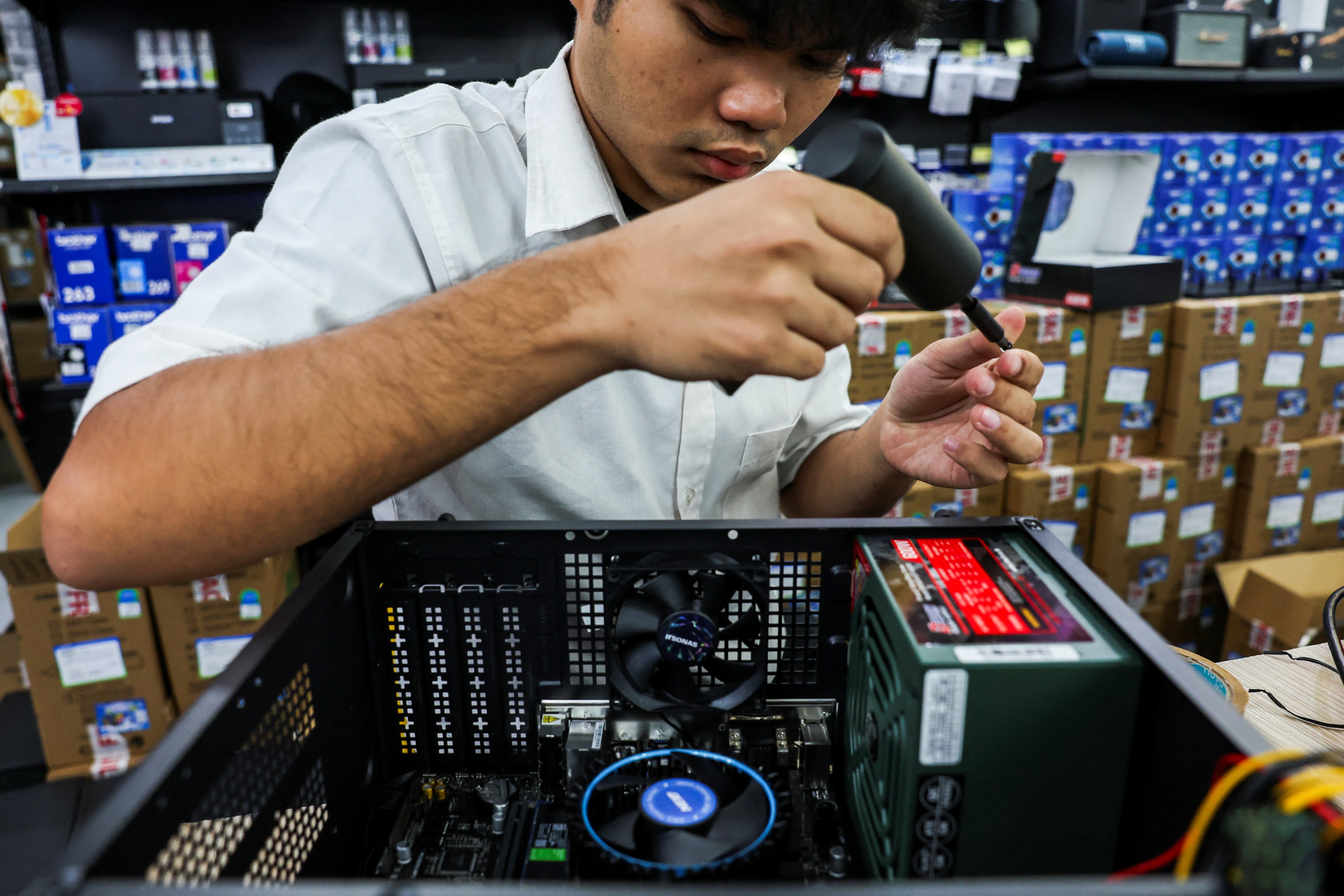 A man builds a custom PC for a customer at an IT store in Bangkok. US President Donald Trump has announce a 19 per cent tariff on goods from Thailand. Photo: Reuters
