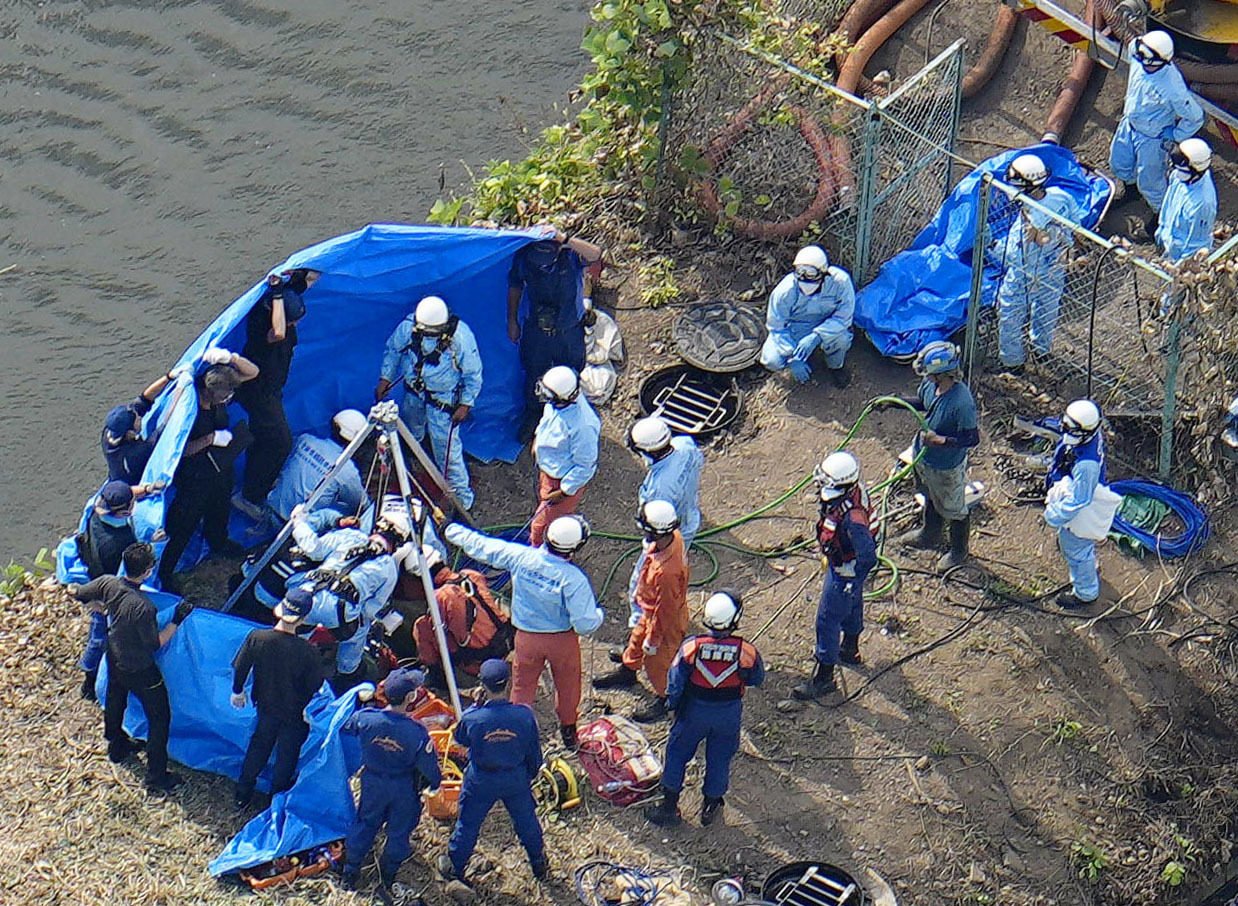 Rescuers look for the stricken workers who fell into a manhole in Gyoda, Saitama prefecture on Saturday. Photo: Kyodo