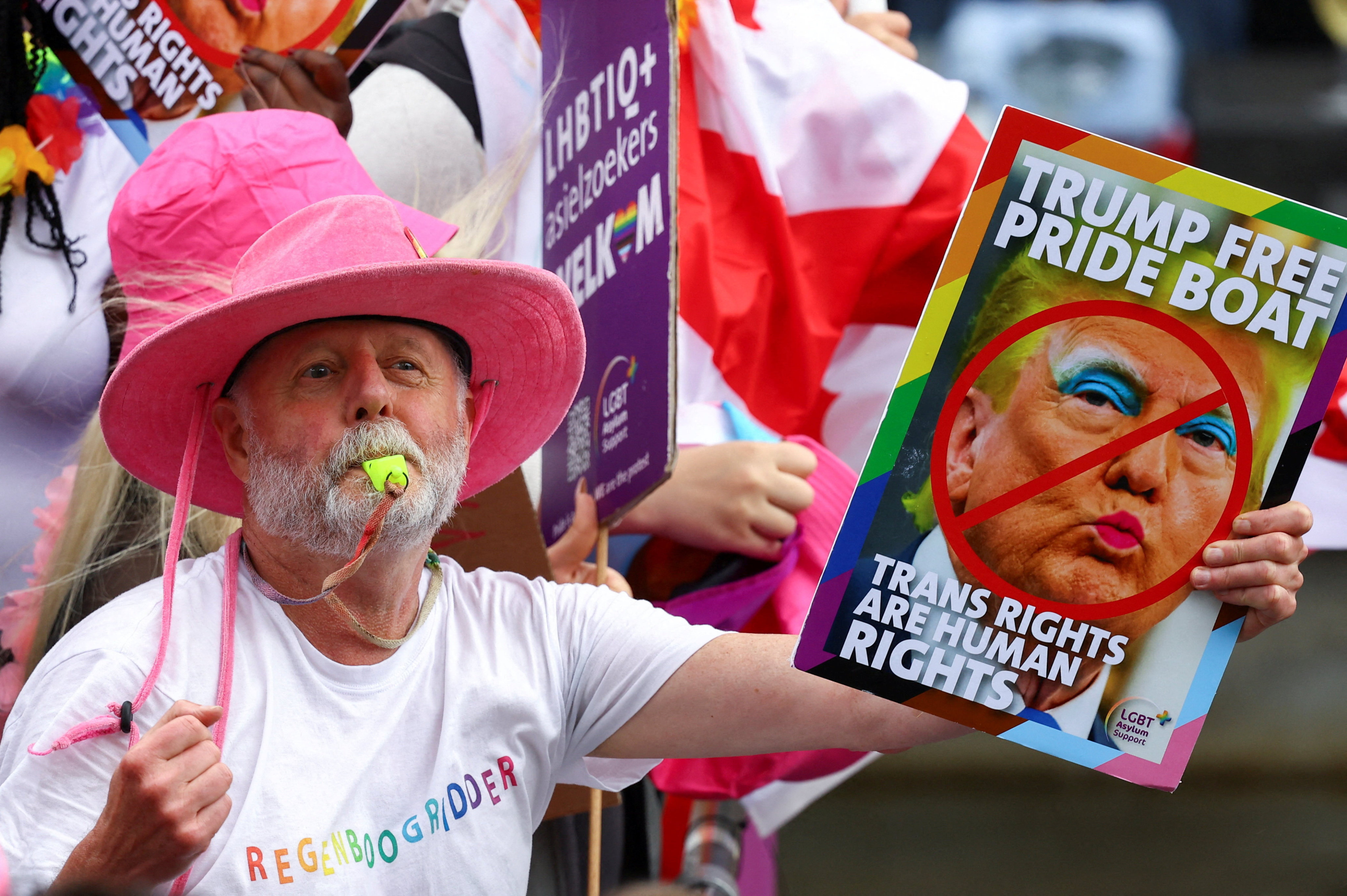 A person holds a sign as boats cruise canals during the annual Pride parade in Amsterdam, Netherlands on Saturday. Photo: Reuters