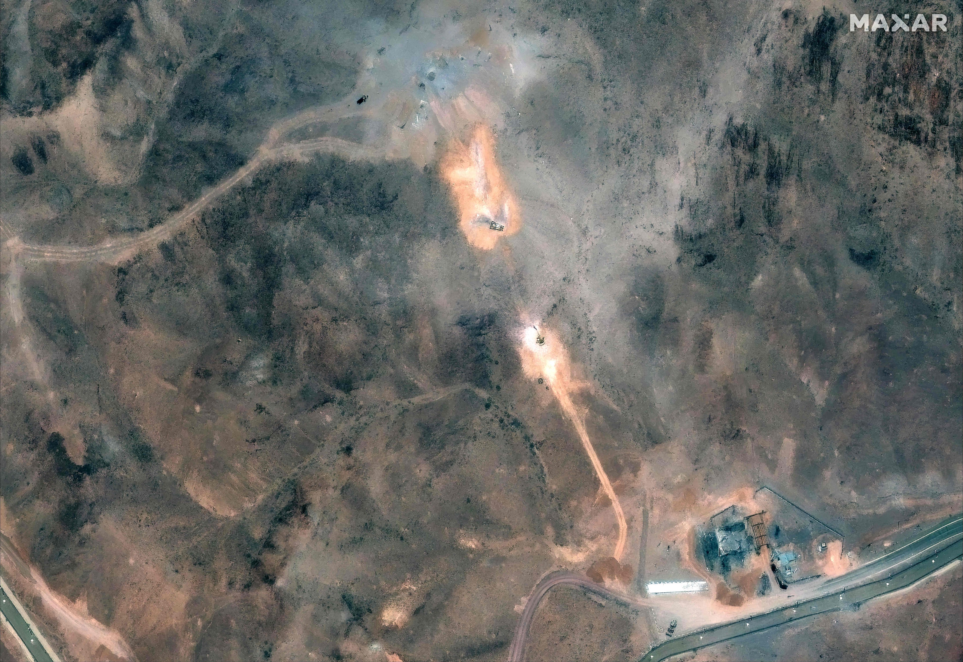 Activity near the perimeter building and southern holes caused by the June 22 US airstrike on the Fordow Fuel Enrichment Plant complex in Iran.: Photo: Satellite image ©2025 Maxar Technologies/AFP