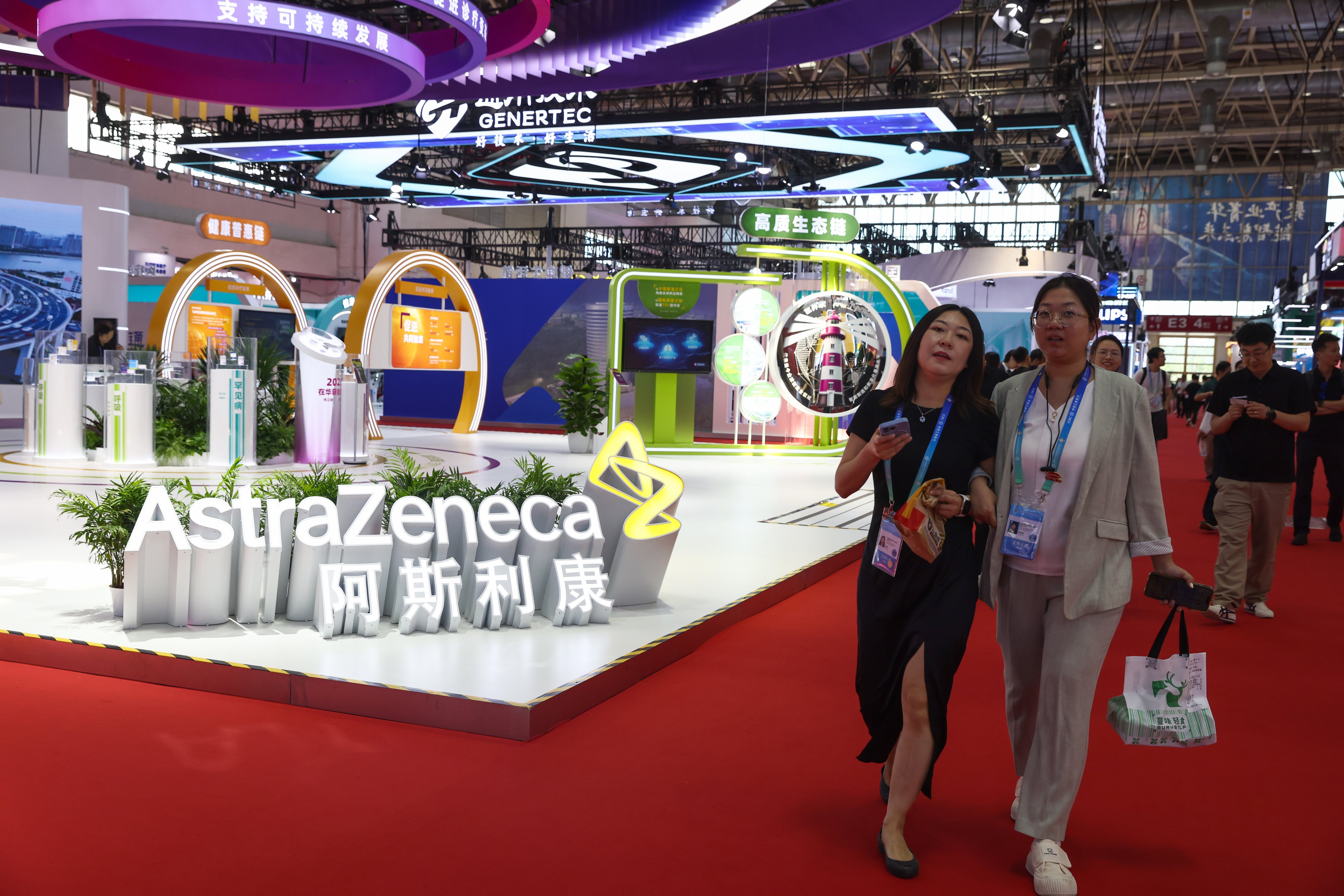 Visitors walk beside the booth of British-Swedish multinational pharmaceutical and biotechnology company AstraZeneca during the third China International Supply Chain Expo in Beijing on July 17. Photo: EPA