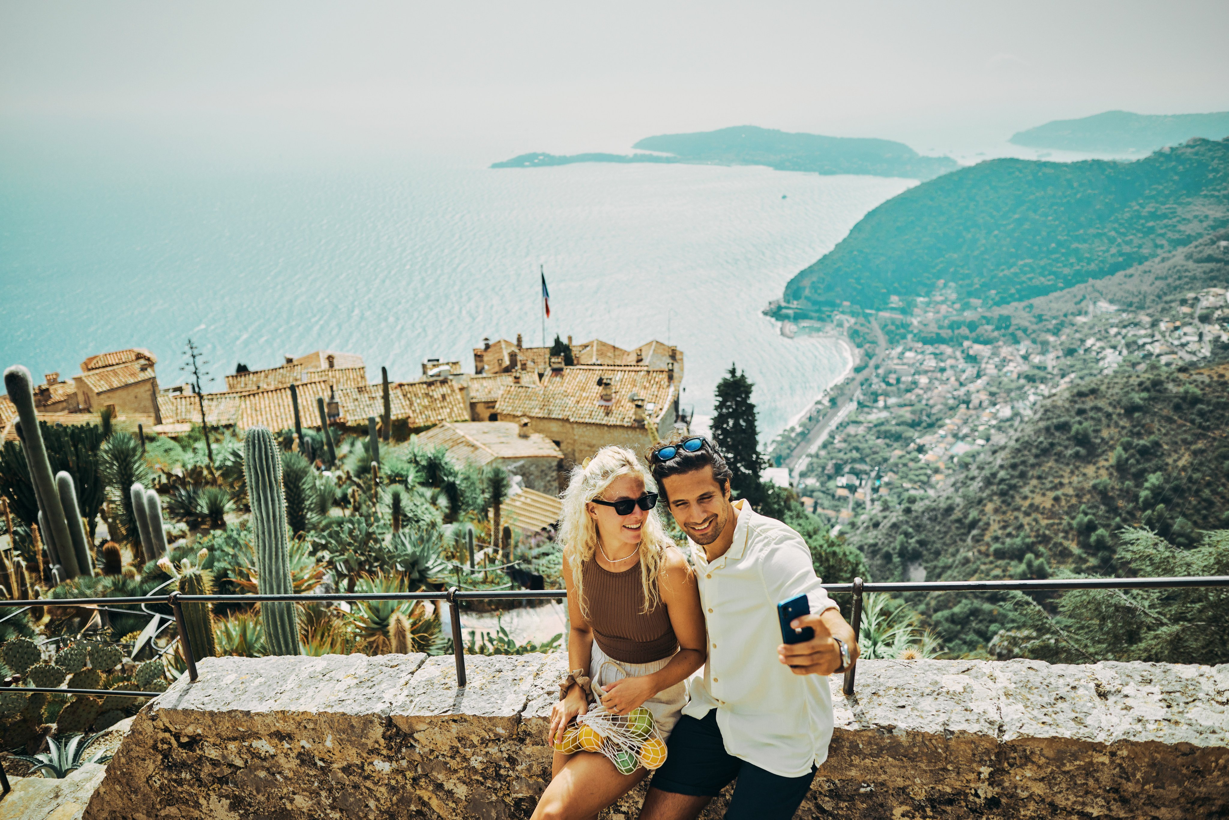 Holidaymakers take a selfie in the historic village of Èze in the south of France. Discerning luxury travellers are avoiding the tourist traps and influencer hangouts for stealth holidays in less-visited locations like Èze. Photo: Shutterstock