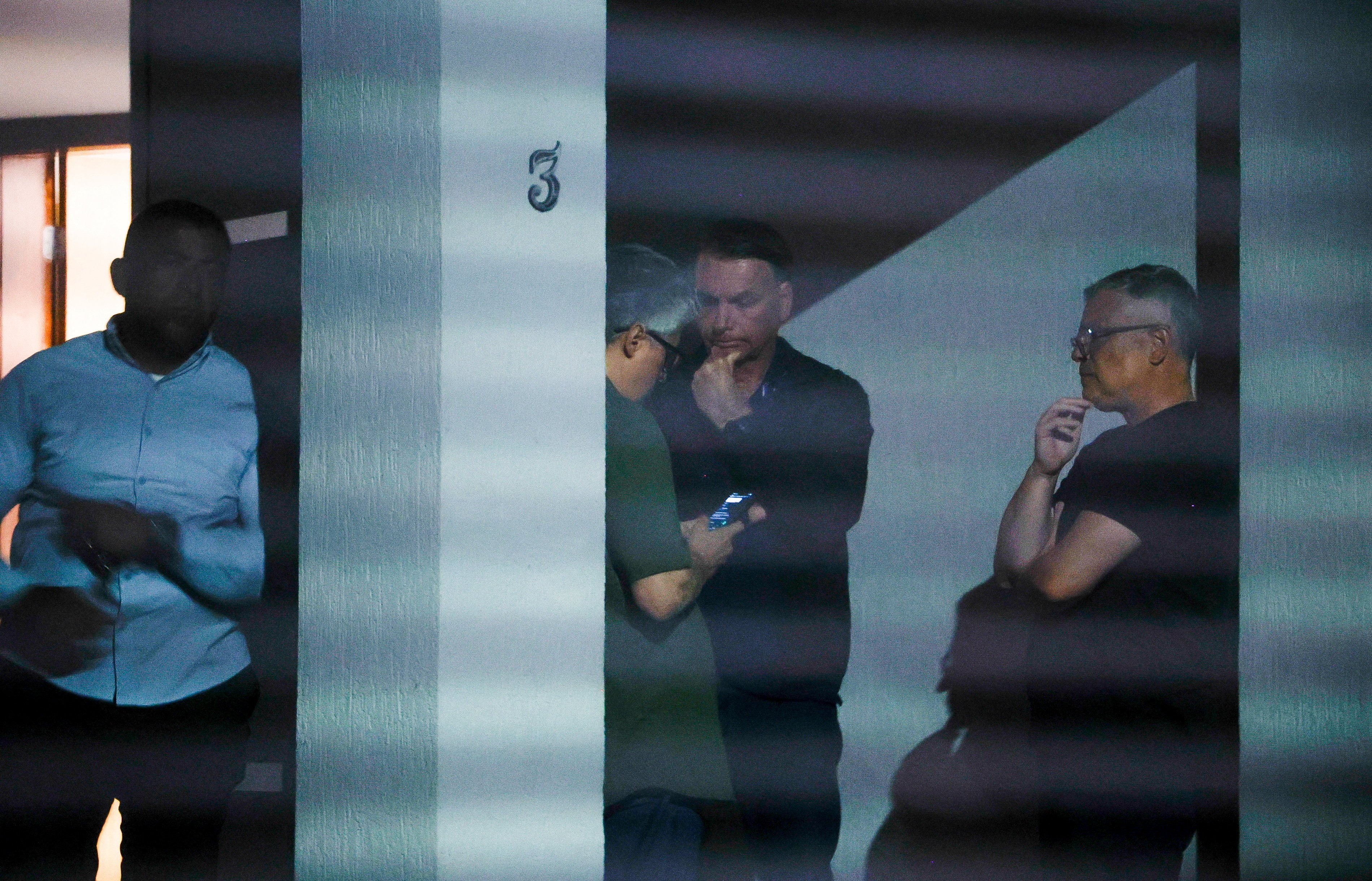 Brazil’s former president Jair Bolsonaro talks to unidentified people at his home after Brazil’s Supreme Court put him under house arrest. Photo: Folhapress via Reuters