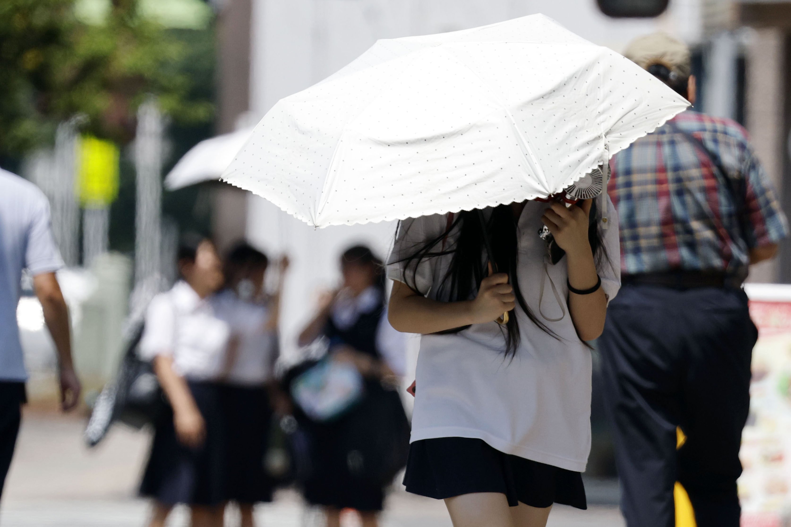 People walk under the scorching sun in Kumagaya, Japan’s Saitama prefecture, on Tuesday. Photo: Kyodo