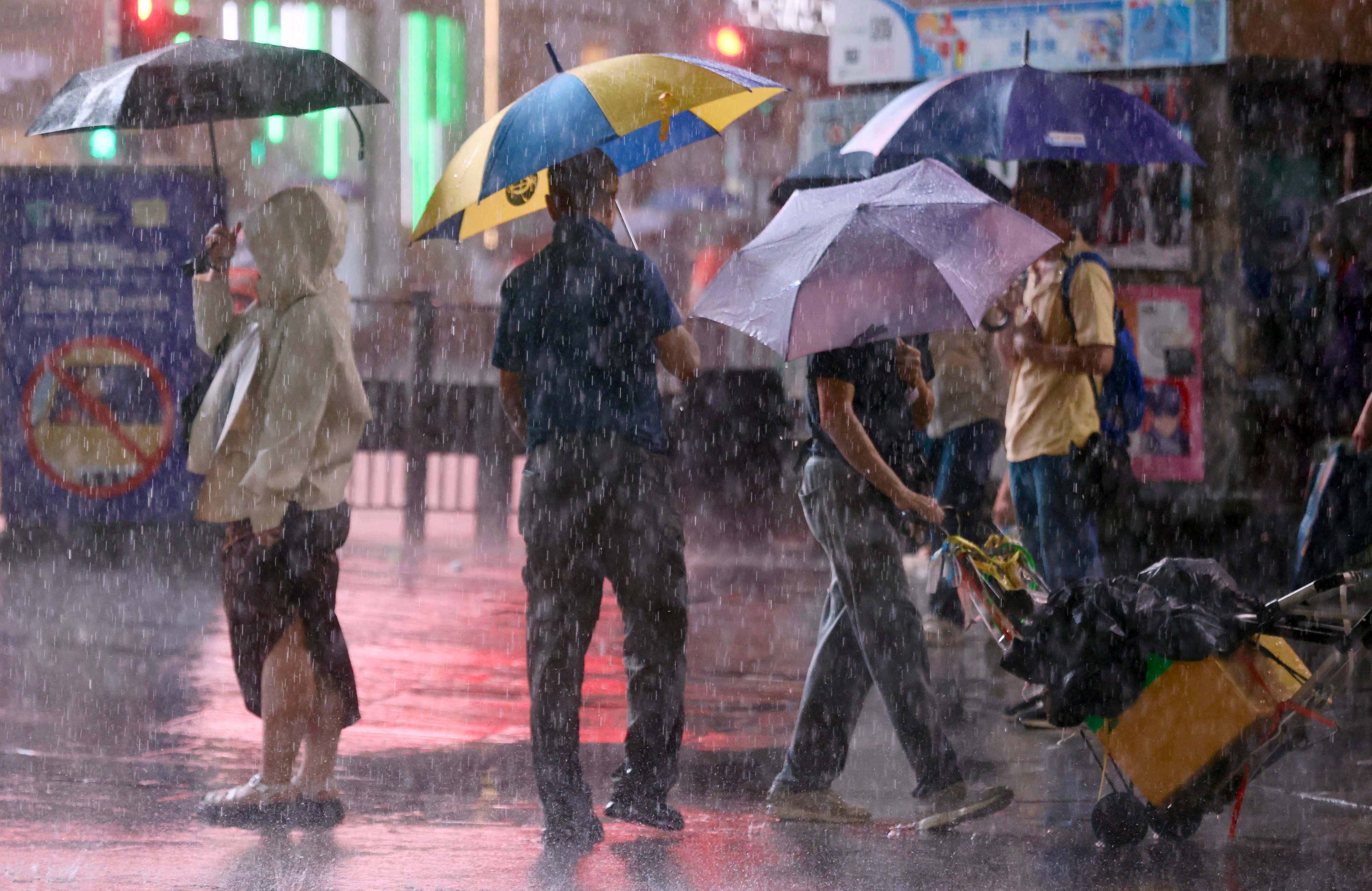 People brave the rain amid a black rainstorm warning on Tuesday. Photo: Jonathan Wong