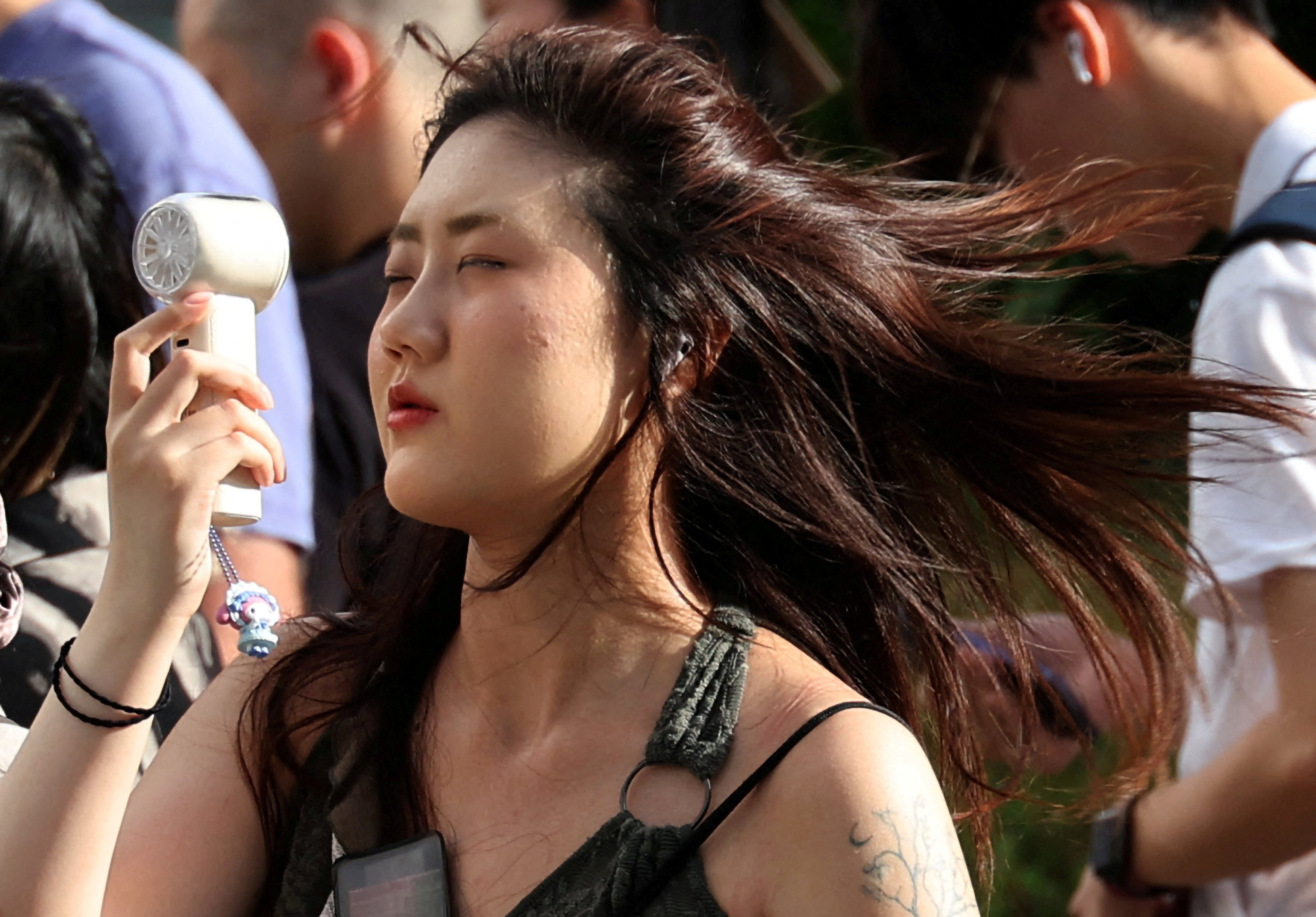 A woman uses a portable fan to cool herself during a heatwave in Tokyo, Japan, on July 17. Photo: Reuters