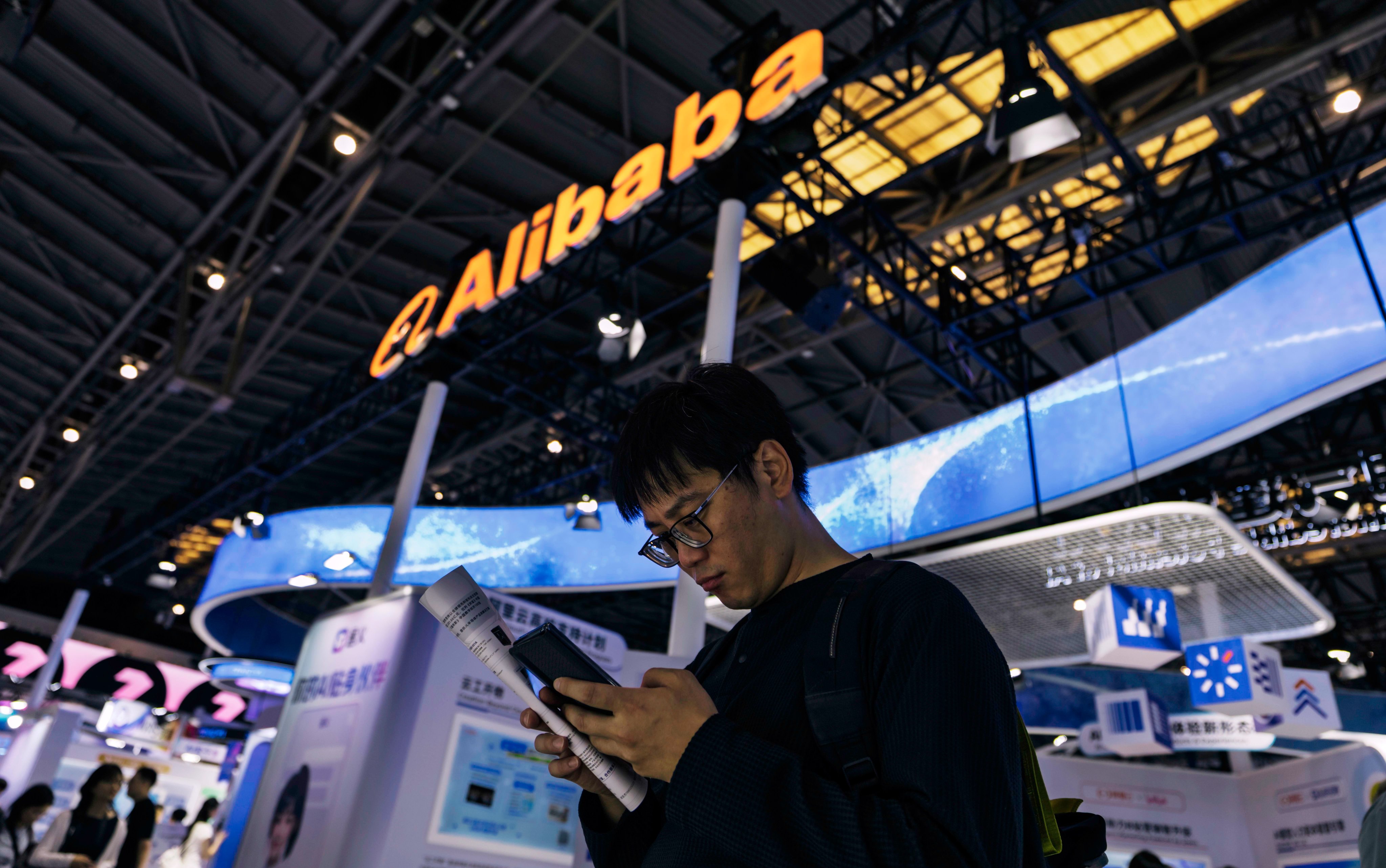 A man stands in front of the Alibaba booth during the World Artificial Intelligence Conference in Shanghai, July 28 2025. Photo: EPA