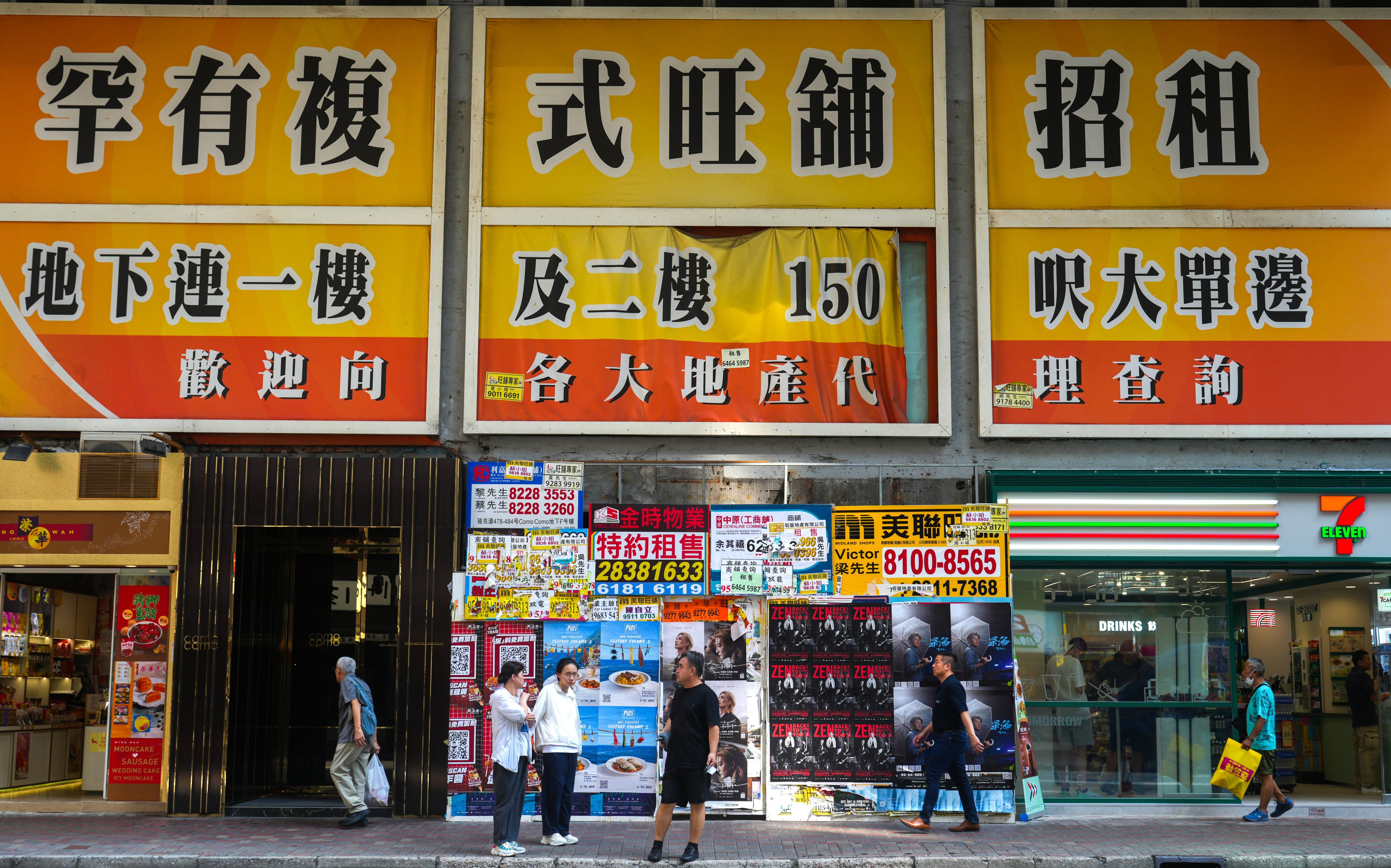 Pedestrians walk under an enormous rental advertisement for a duplex store in Causeway Bay on July 7. Photo: Sam Tsang