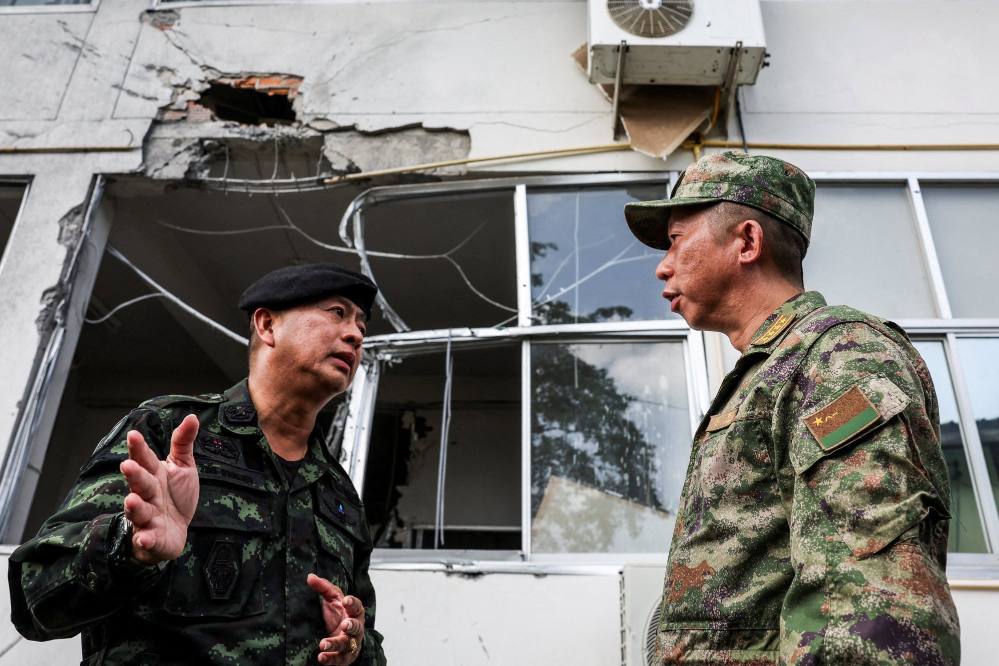 A military attache from China (right) speaks to a member of Thai military personnel as they inspect a damaged hospital caused by shelling in Sisaket province on August 1. Photo: Reuters