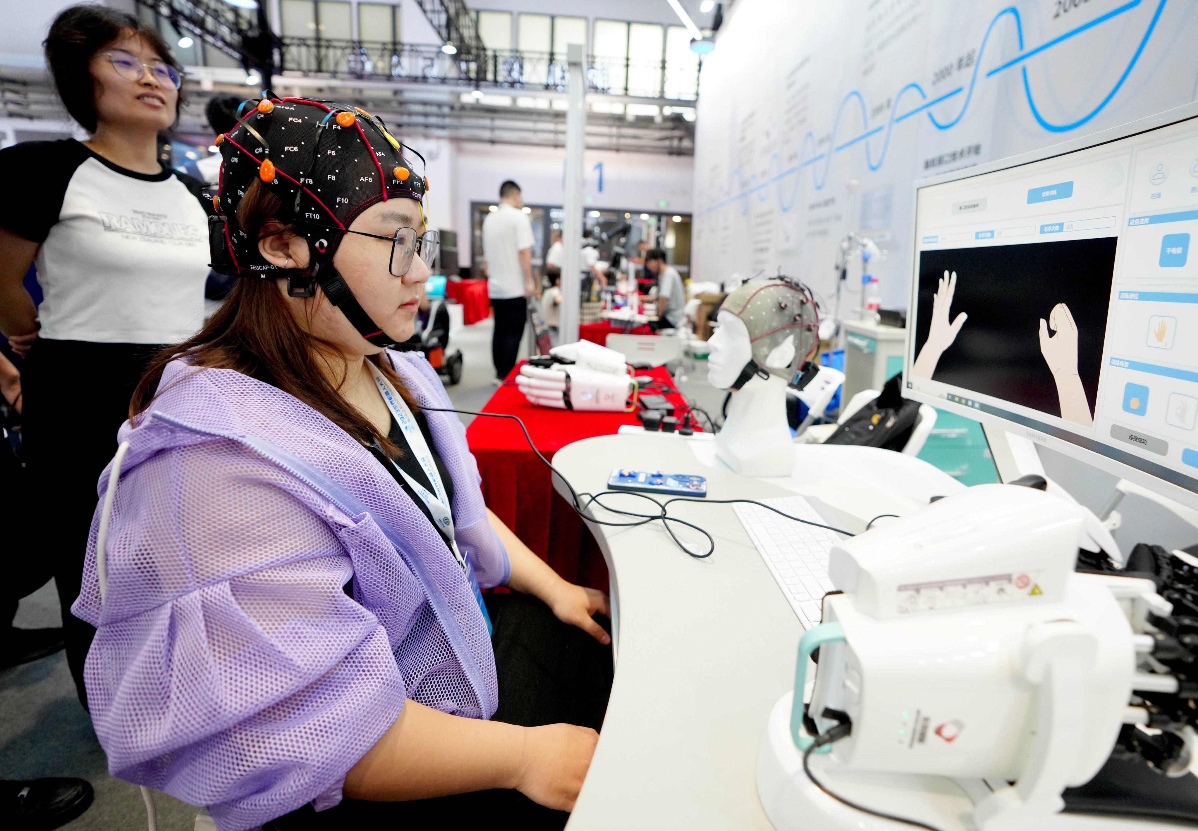 A staff member demonstrates a brain-computer interface for post-stroke rehabilitation at the World Robot Conference 2023 in Beijing. Photo: Xinhua