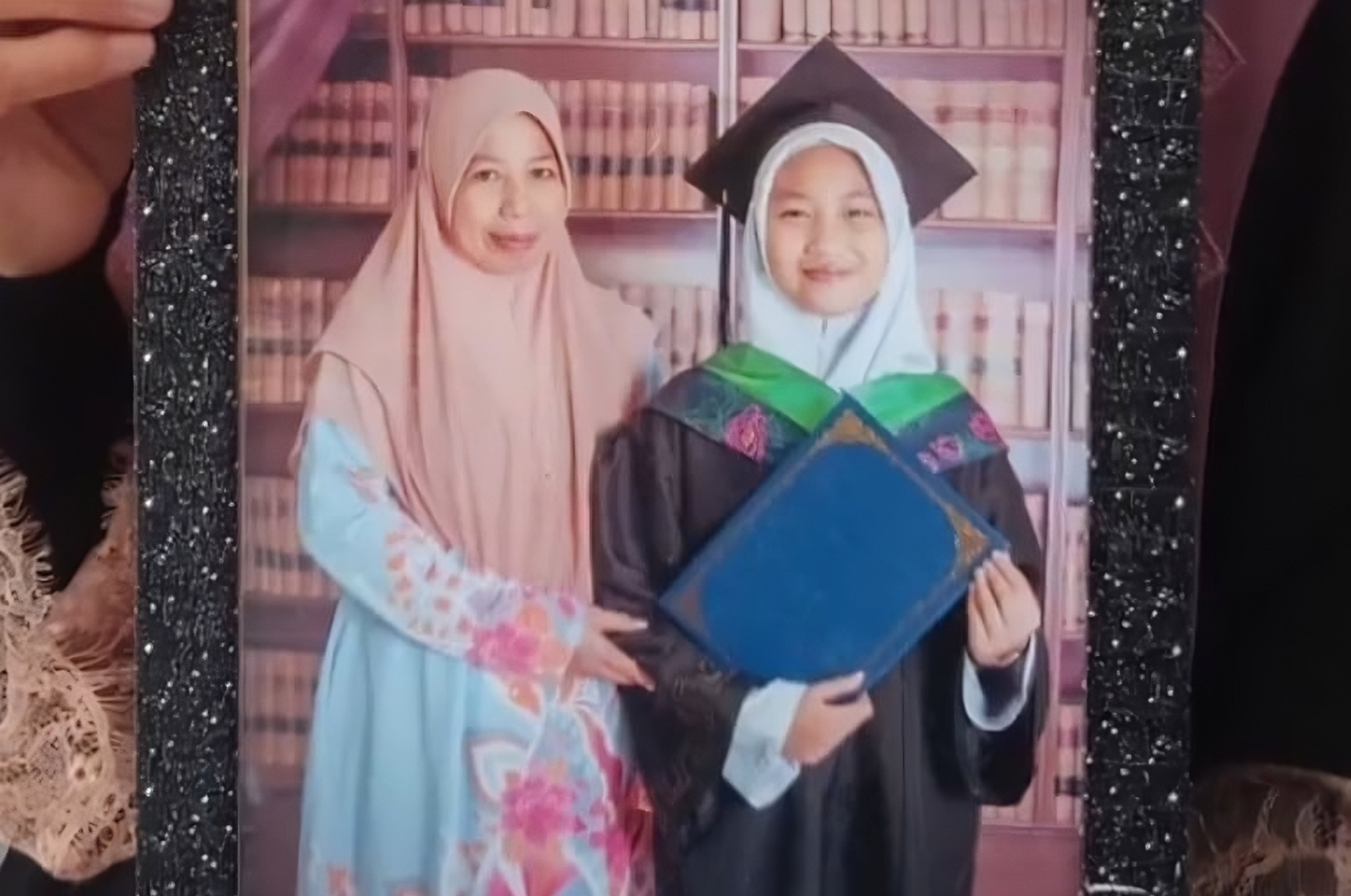 A still from a video circulated on social media shows Zara Qairina Mahathir dressed in academic dress with her mother, Noraidah Lamat. Photo: Facebook