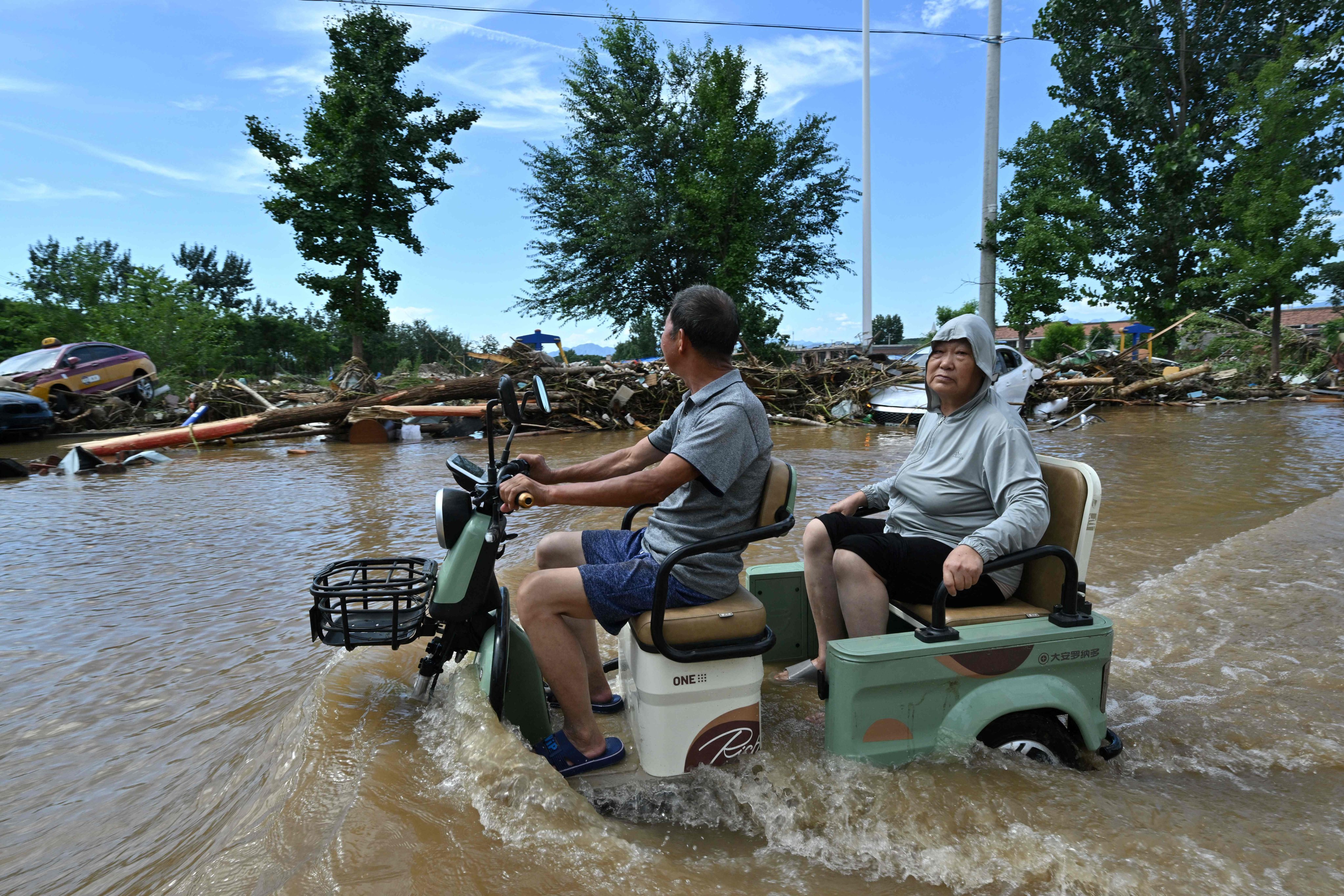 Residents navigate a flooded neighbourhood in northern Beijing in late July. Photo: AFP