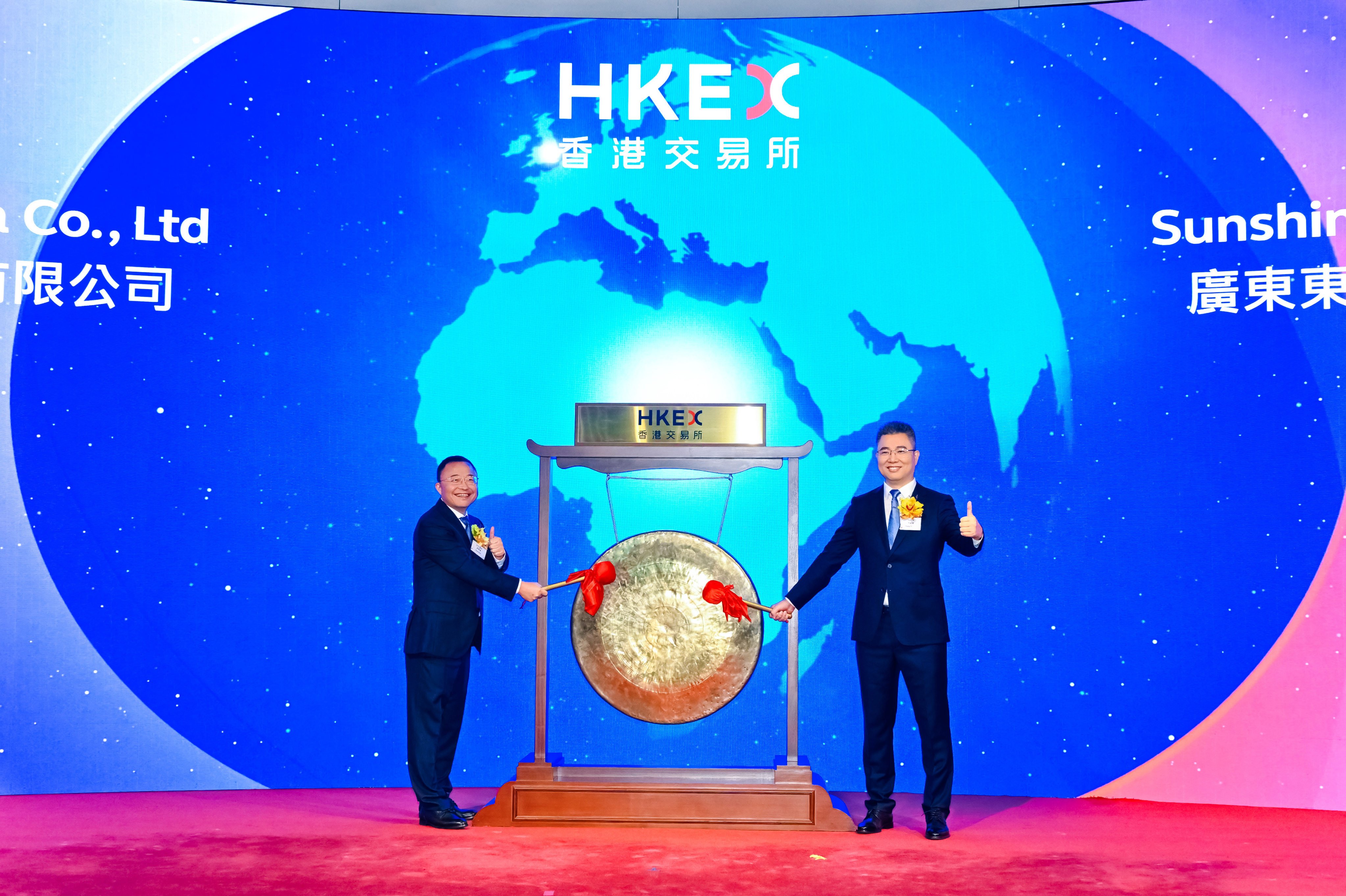 Sunshine Lake Pharma non-executive director Tang Xinfa (left) and chairman and director Zhang Yingjun strike the ceremonial gong at the HKEX’s Connect Hall on Thursday to mark the commencement of trading of the company’s shares. Photo: Handout