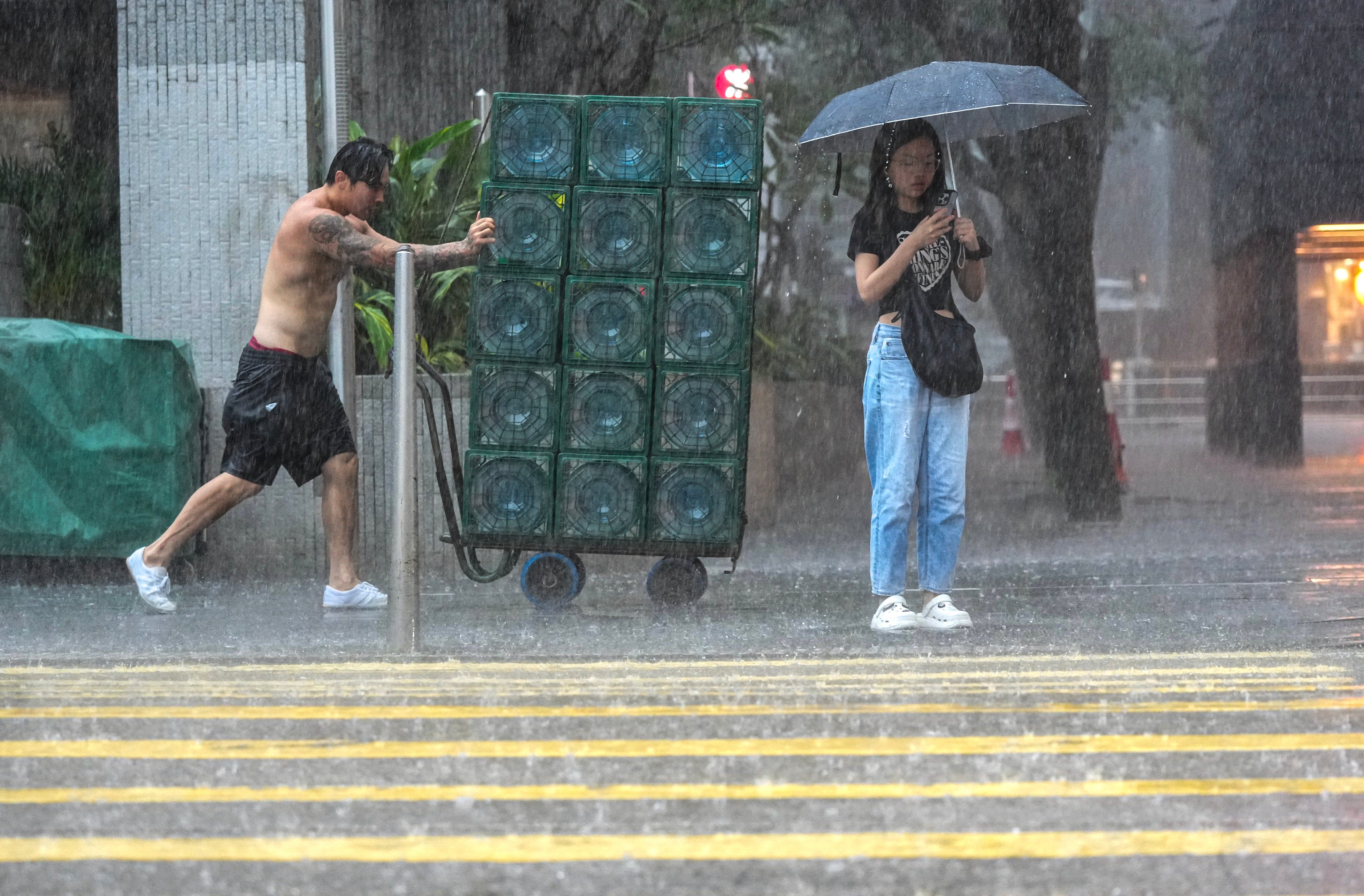 People brave the weather in Central, Hong Kong, during a black rainstorm alert on July 29. Photo: May Tse