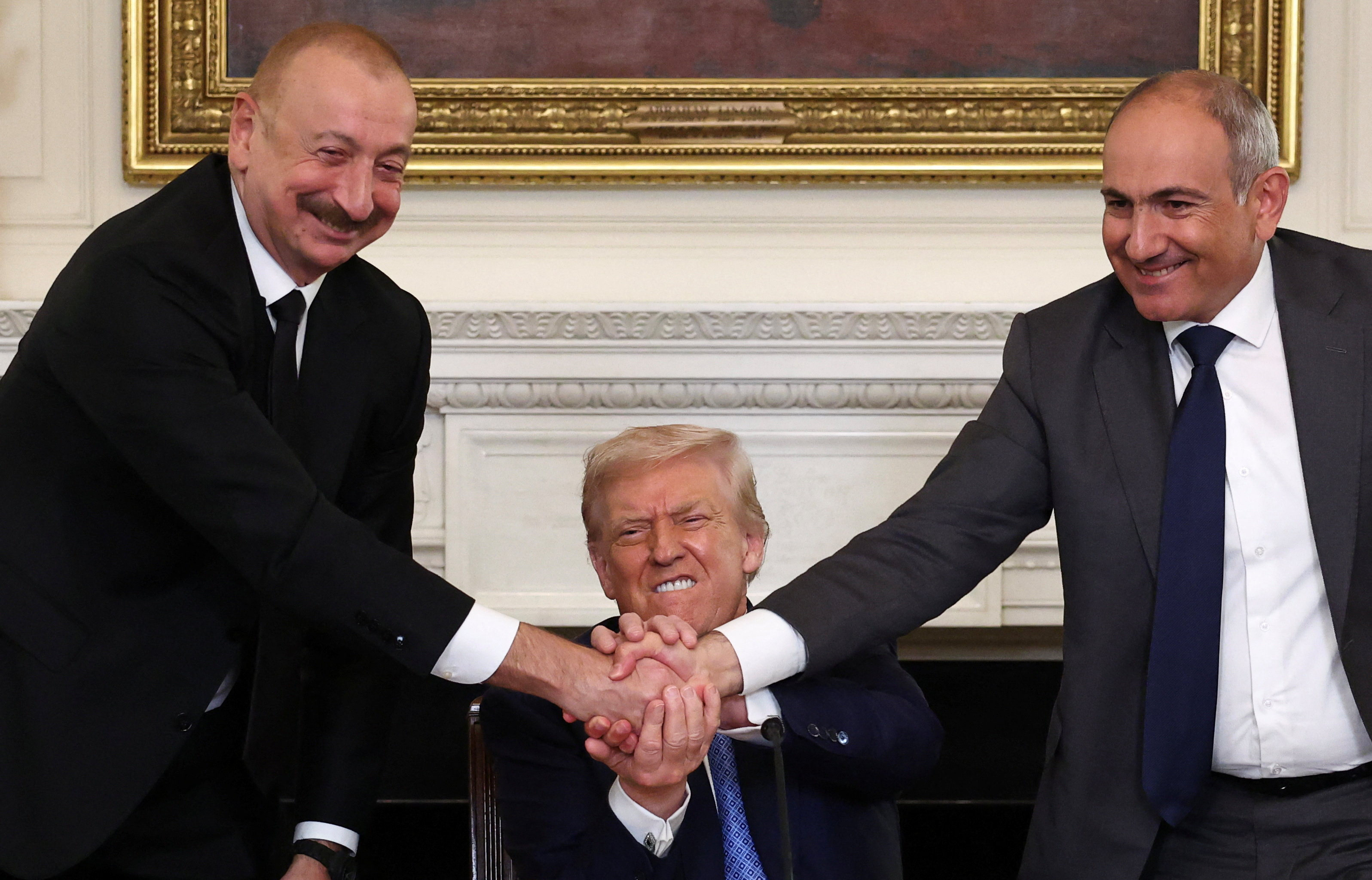 US President Donald Trump holds the hands of Azerbaijan’s President Ilham Aliyev and Armenia’s Prime Minister Nikol Pashinyan during a trilateral signing event on Friday. Photo: Reuters