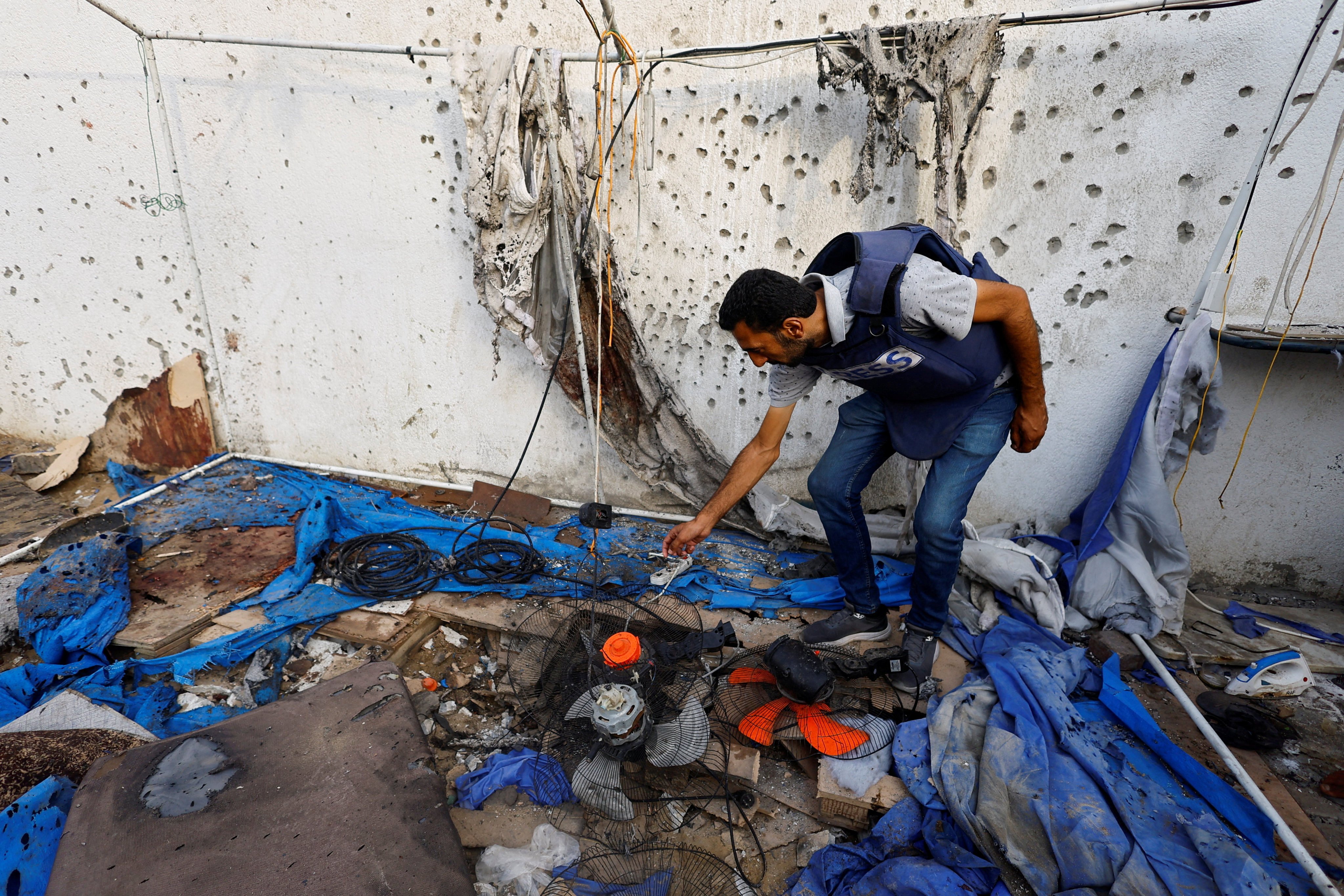 A member of the media inspects the destroyed tent where the Al Jazeera journalists were killed. Photo: Reuters