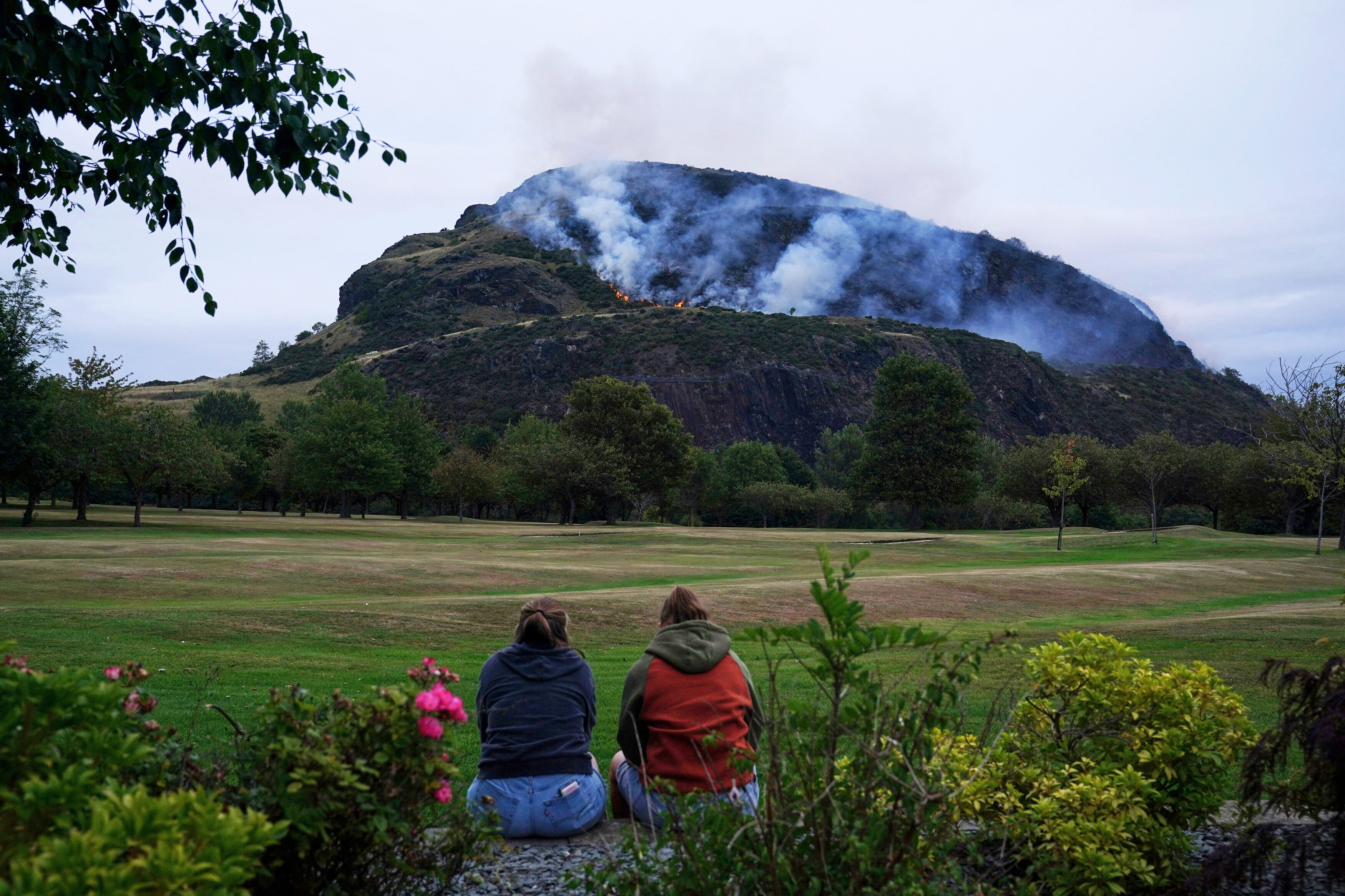 People watch smoke and flames from a fire on Arthur’s Seat. Photo: PA via AP