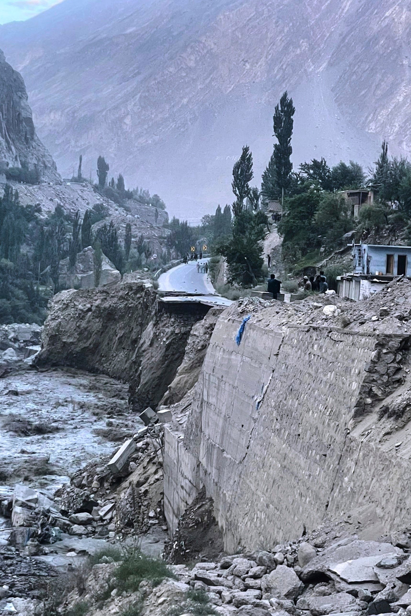 Local residents look a damaged portion of Karakoram Highway following a flash flood triggered by a glacial lake outburst in northern Pakistan on Sunday. Photo: AP