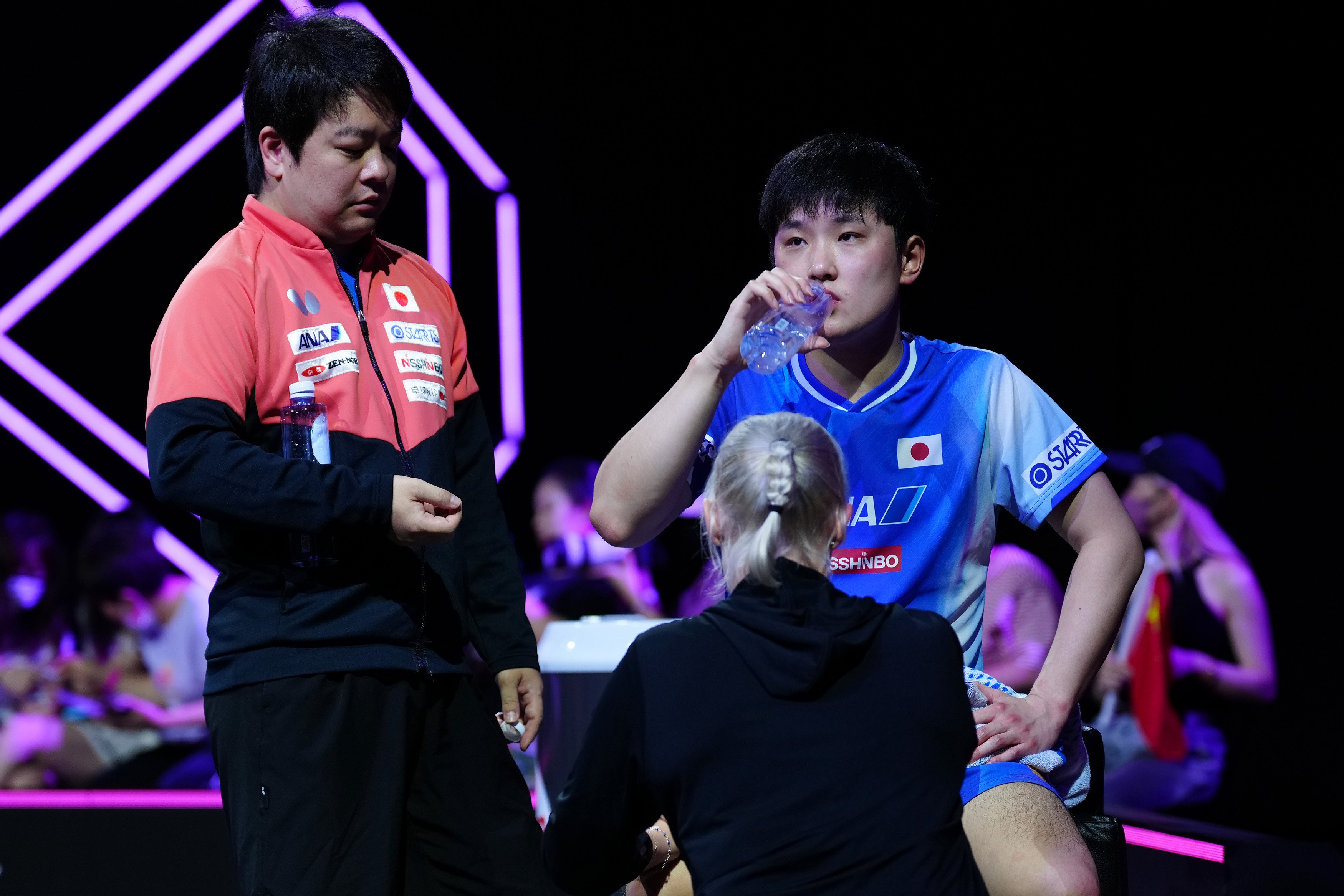 Tomokazu Harimoto (right) being tended to during a medical timeout in the final against Wang Chuqin on Monday. Photo: Xinhua