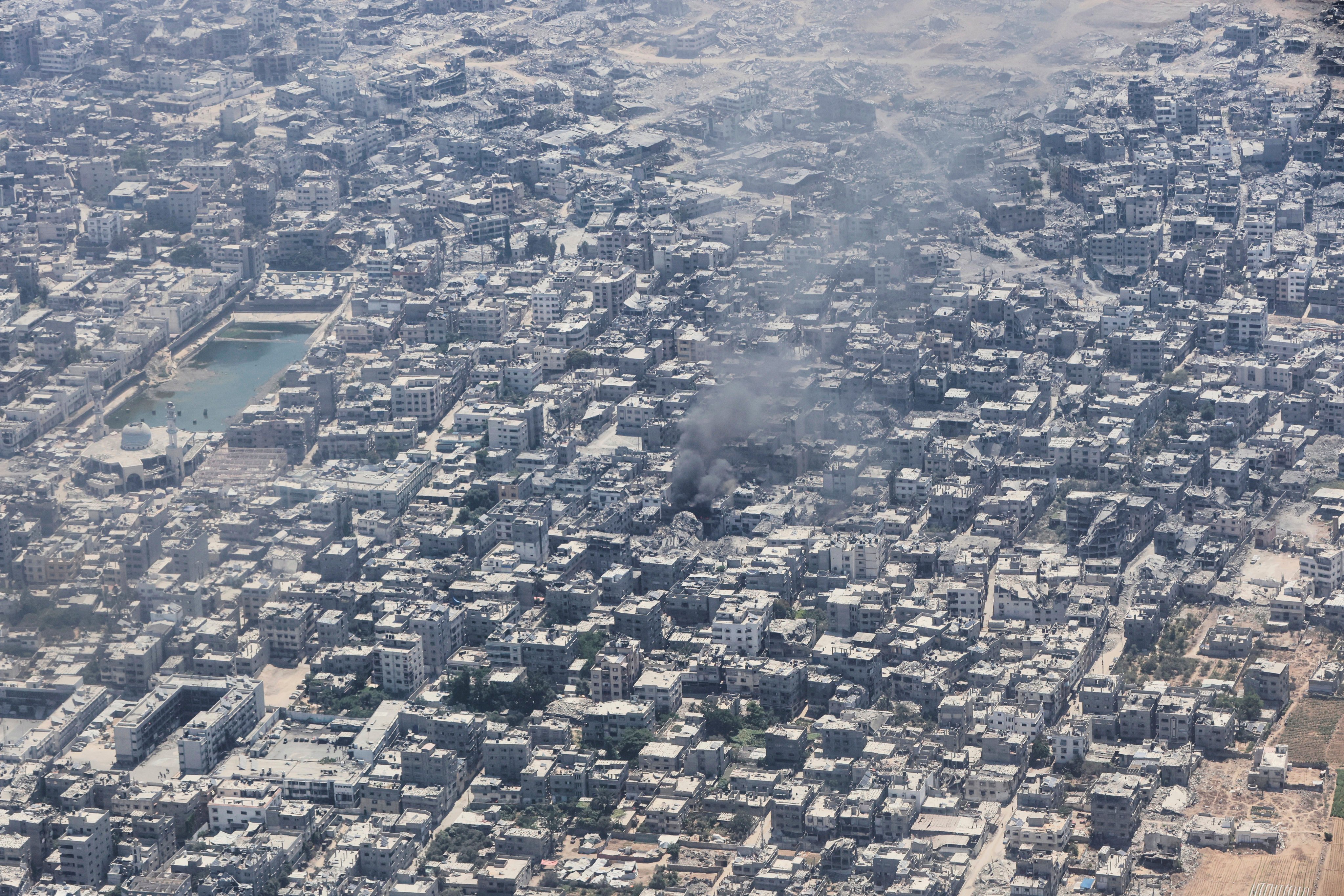 Smoke rises from Gaza City as seen seen from a Jordanian Air Force C-130 plane during an airdrop of humanitarian aid for Palestinians. Photo: AP